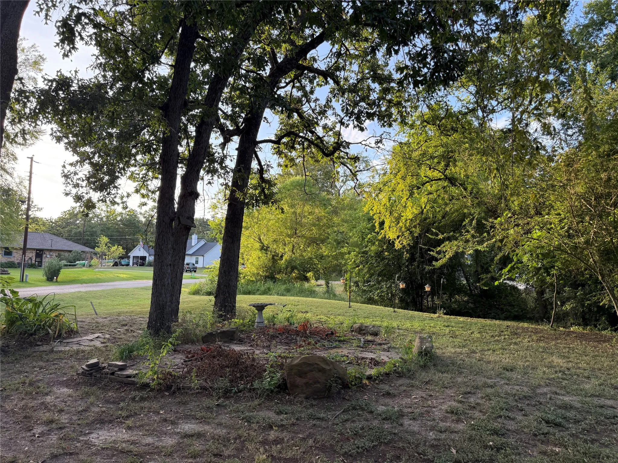 View of green lawn featuring view of wooded area