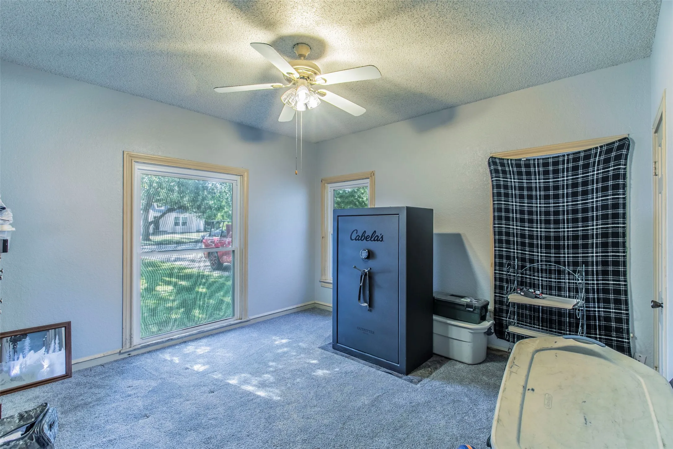 Carpeted home office featuring a textured ceiling and ceiling fan