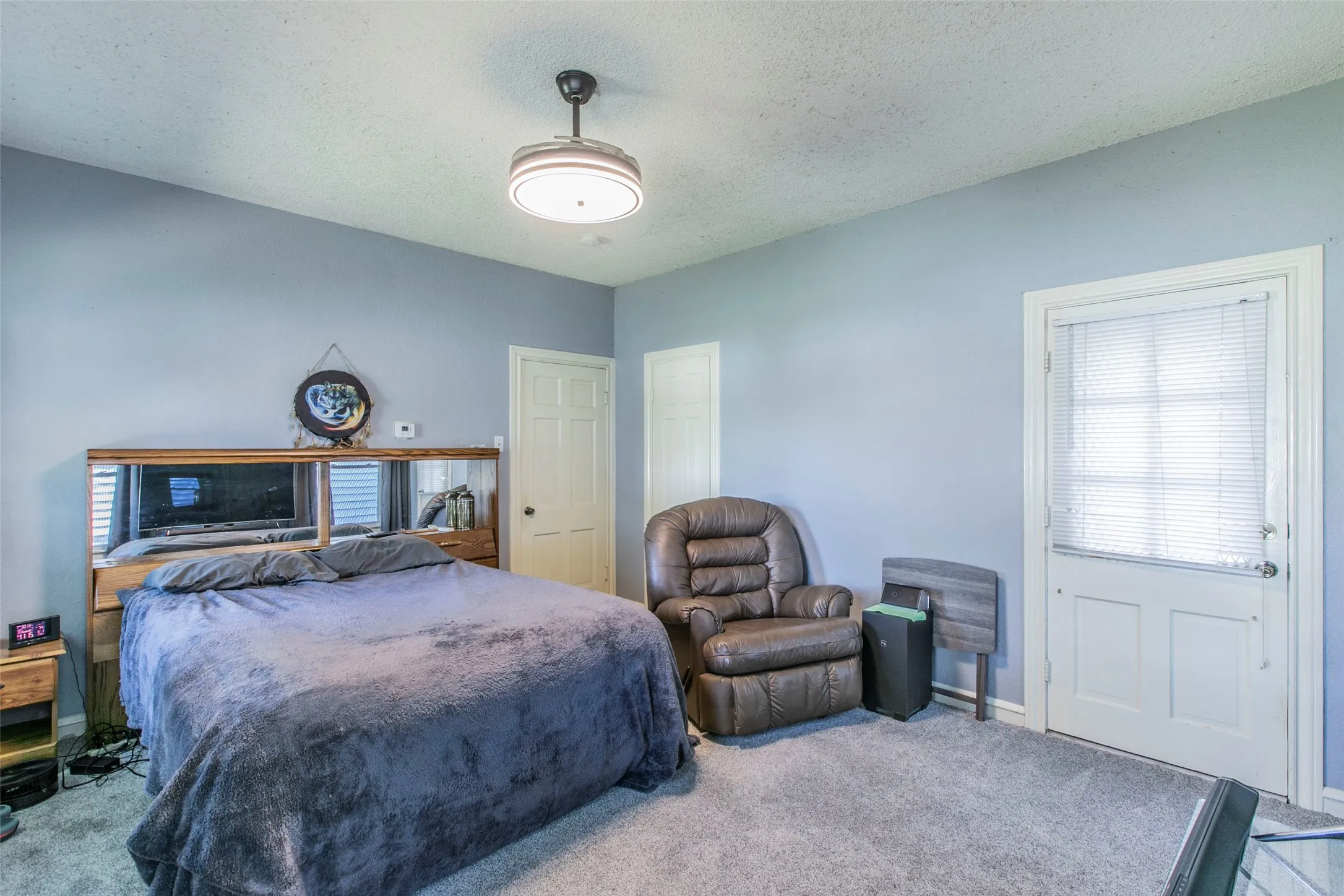 Carpeted bedroom with a textured ceiling and baseboards