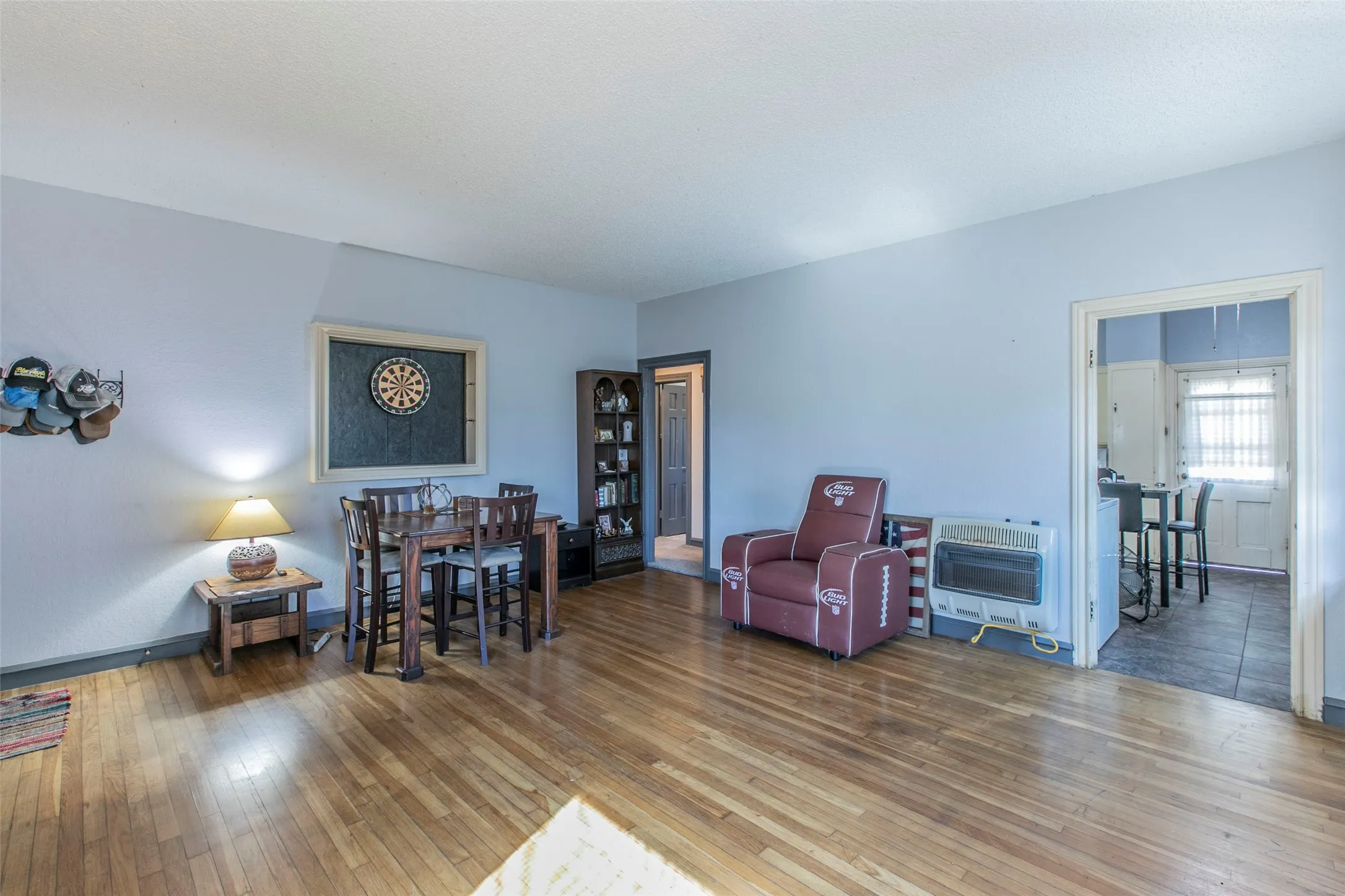Living room with heating unit and hardwood / wood-style floors