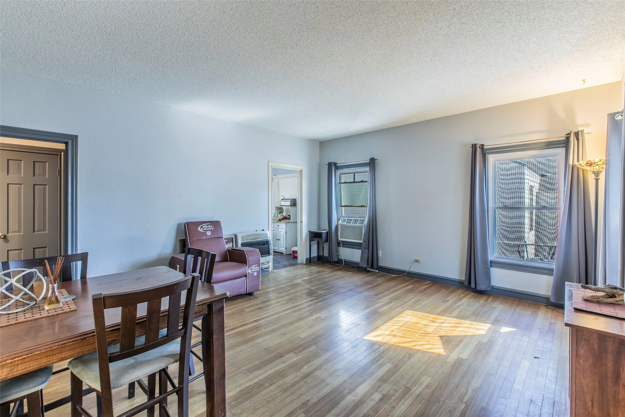 Dining area with wood finished floors, a textured ceiling, and plenty of natural light