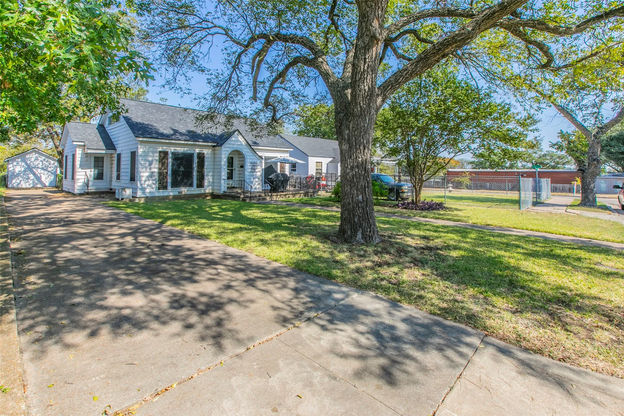 View of front of property with an outdoor structure, roof with shingles, and a garage
