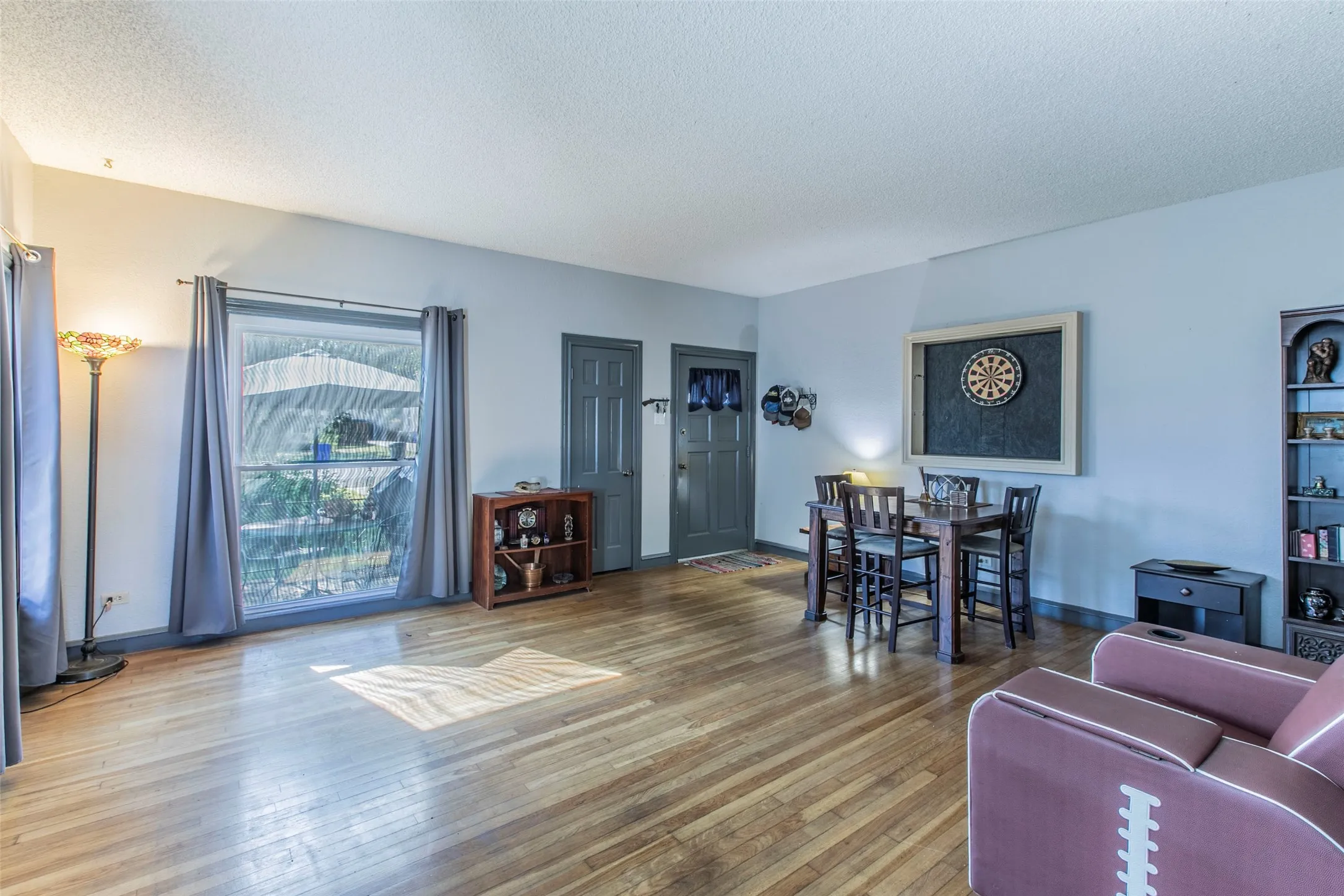 Living area featuring wood-type flooring and a textured ceiling