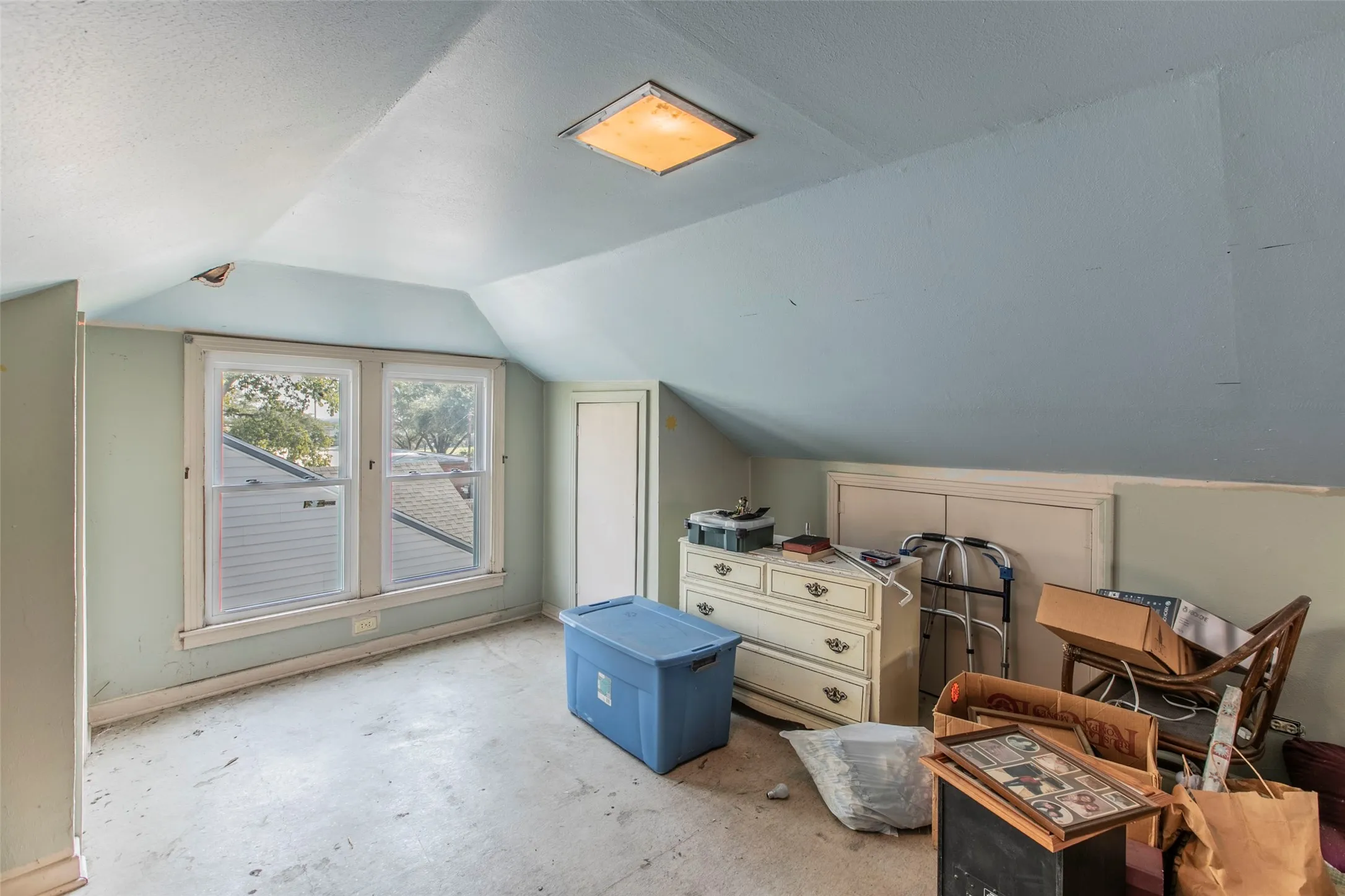 Additional living space featuring vaulted ceiling and concrete floors
