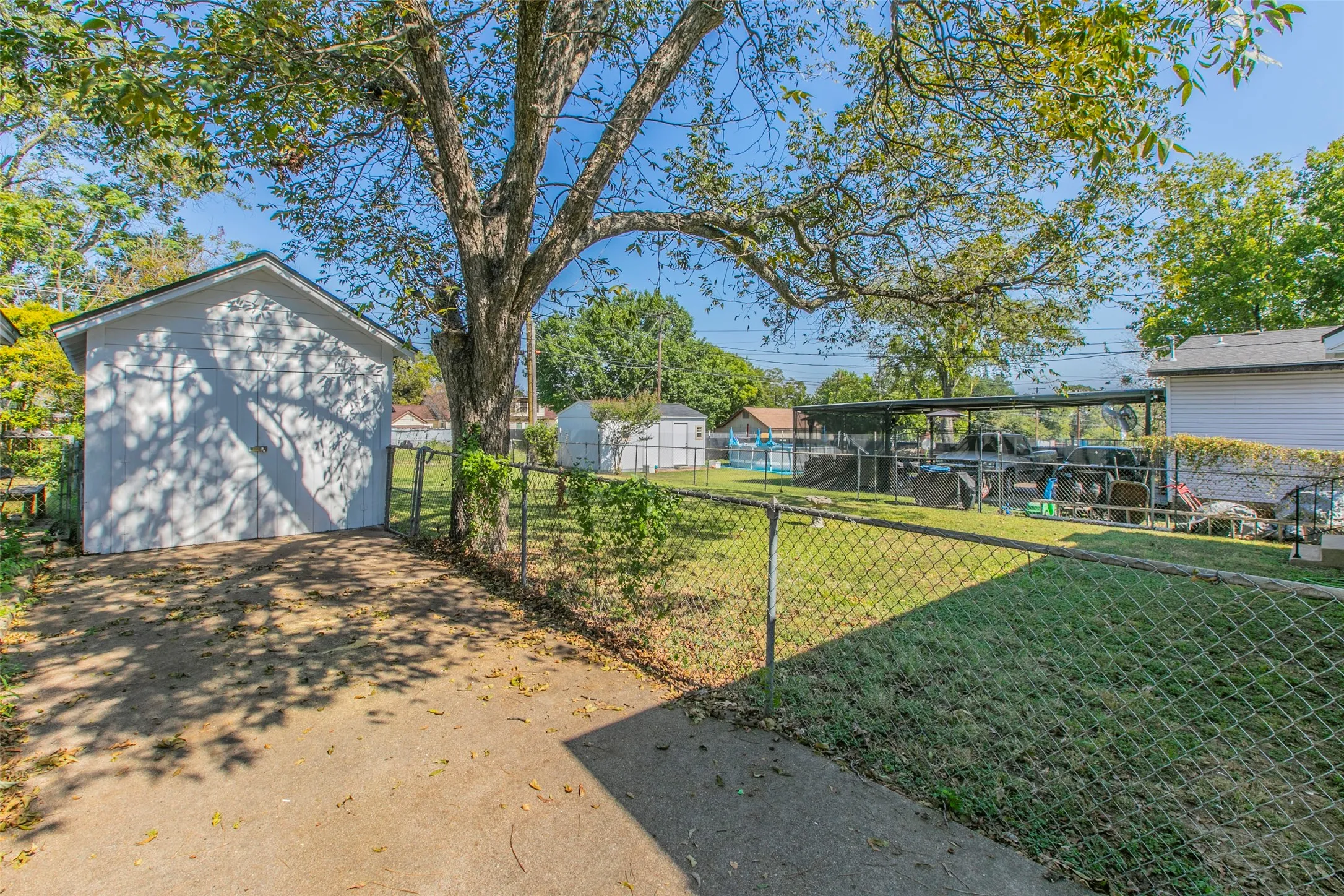 Fenced backyard featuring a storage shed