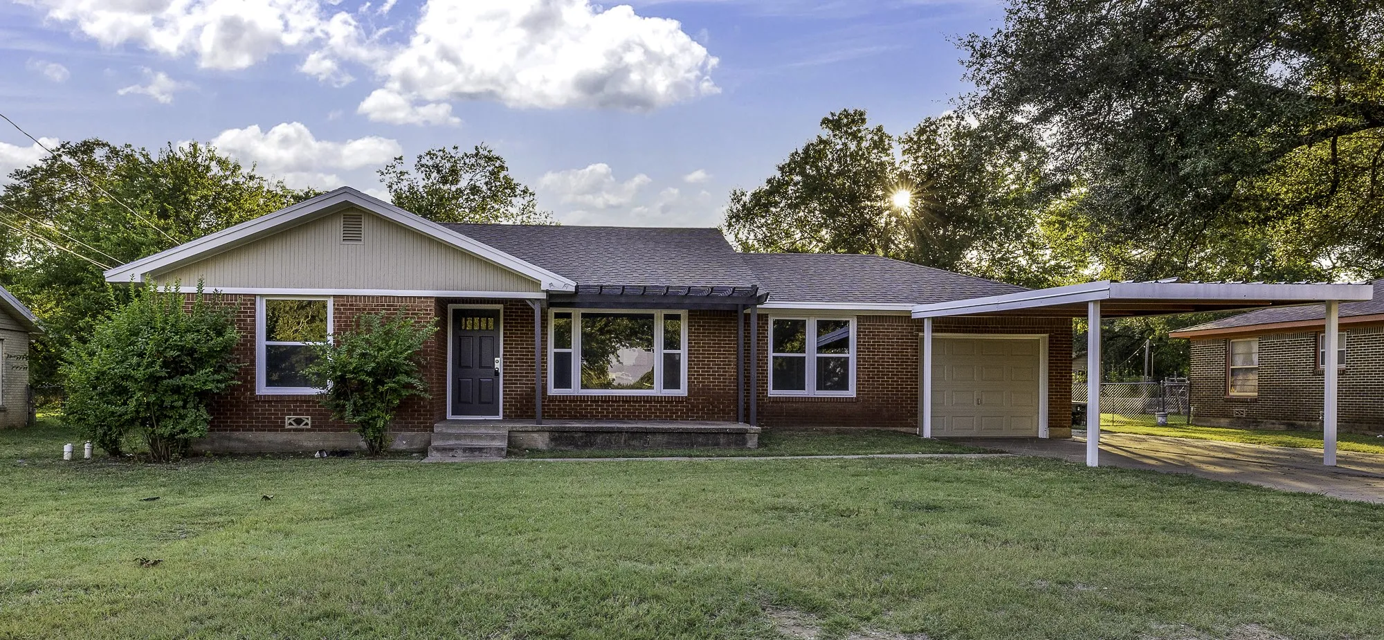 Ranch-style home with brick siding, a front lawn, a garage, and roof with shingles