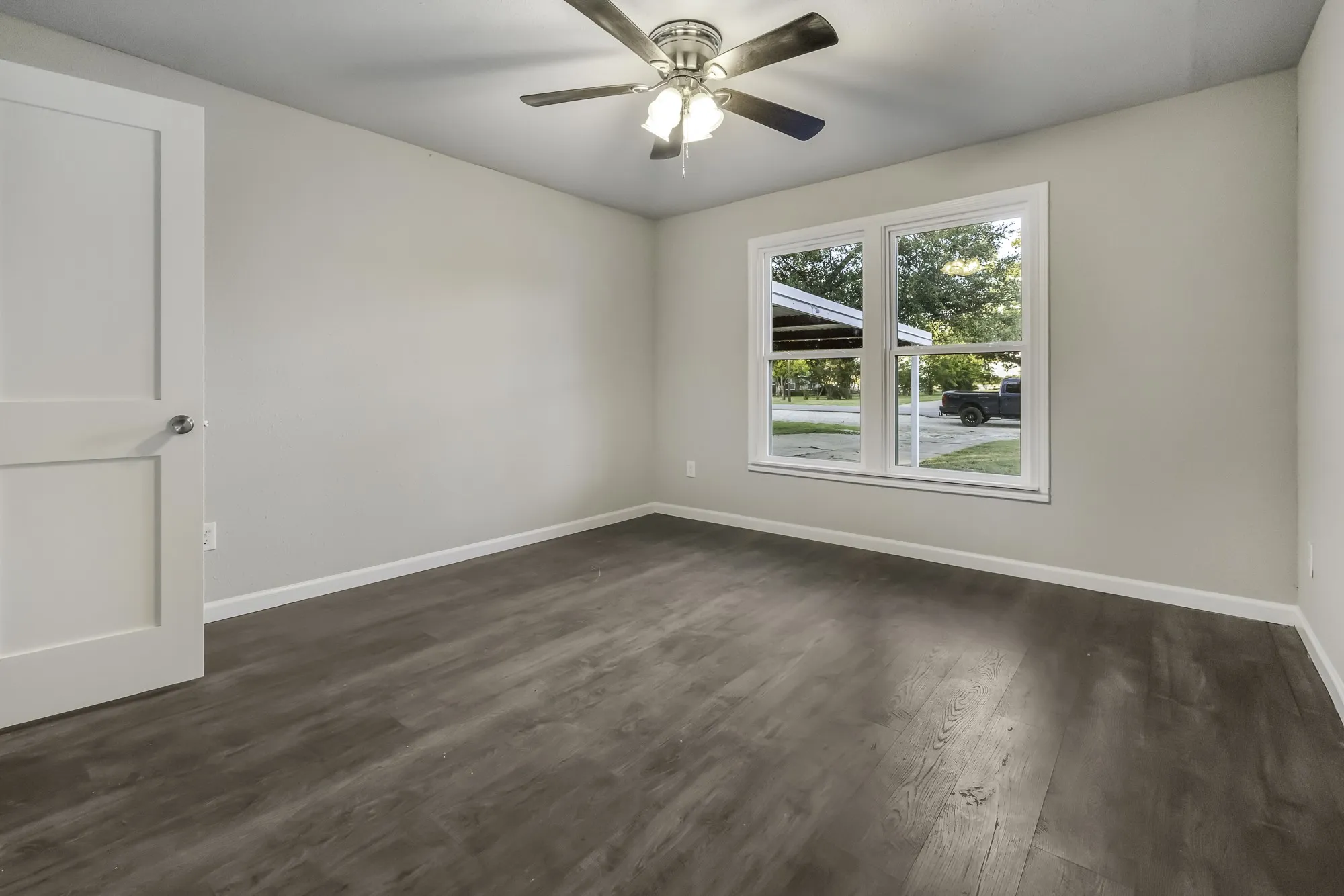 Spare room with dark wood finished floors and ceiling fan