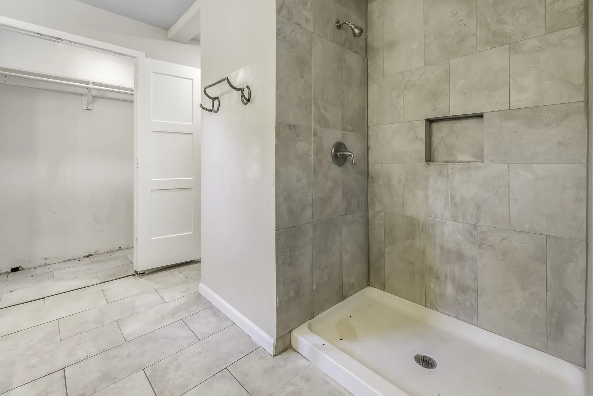 Bathroom with a stall shower, tile patterned flooring, and a walk in closet