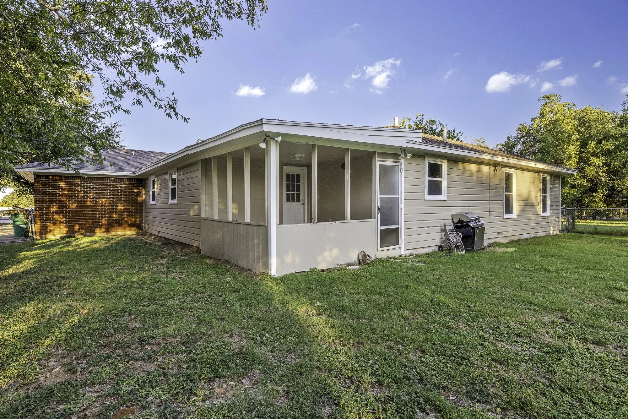 Rear view of house with a sunroom and a yard