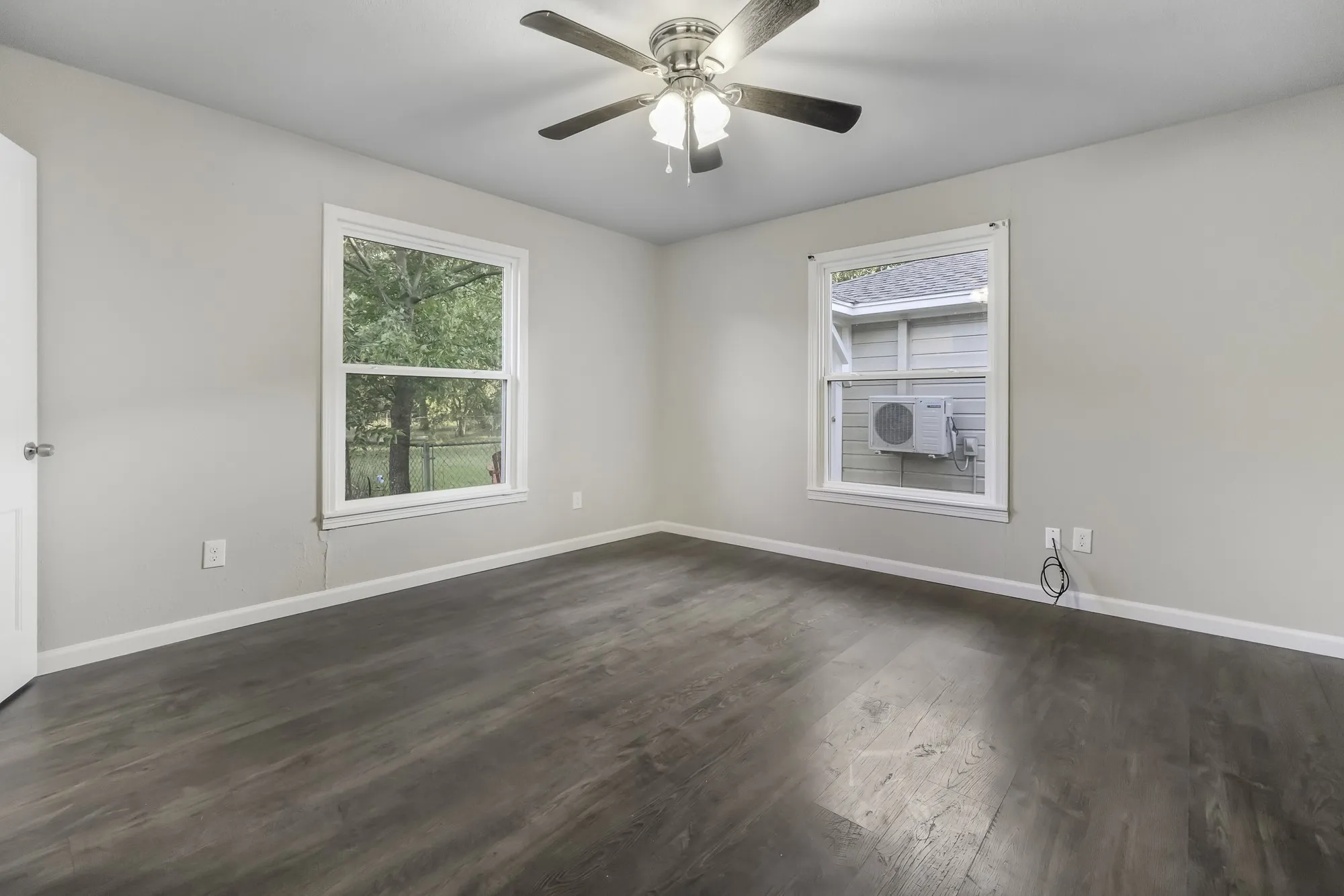 Unfurnished room featuring dark wood-type flooring and ceiling fan