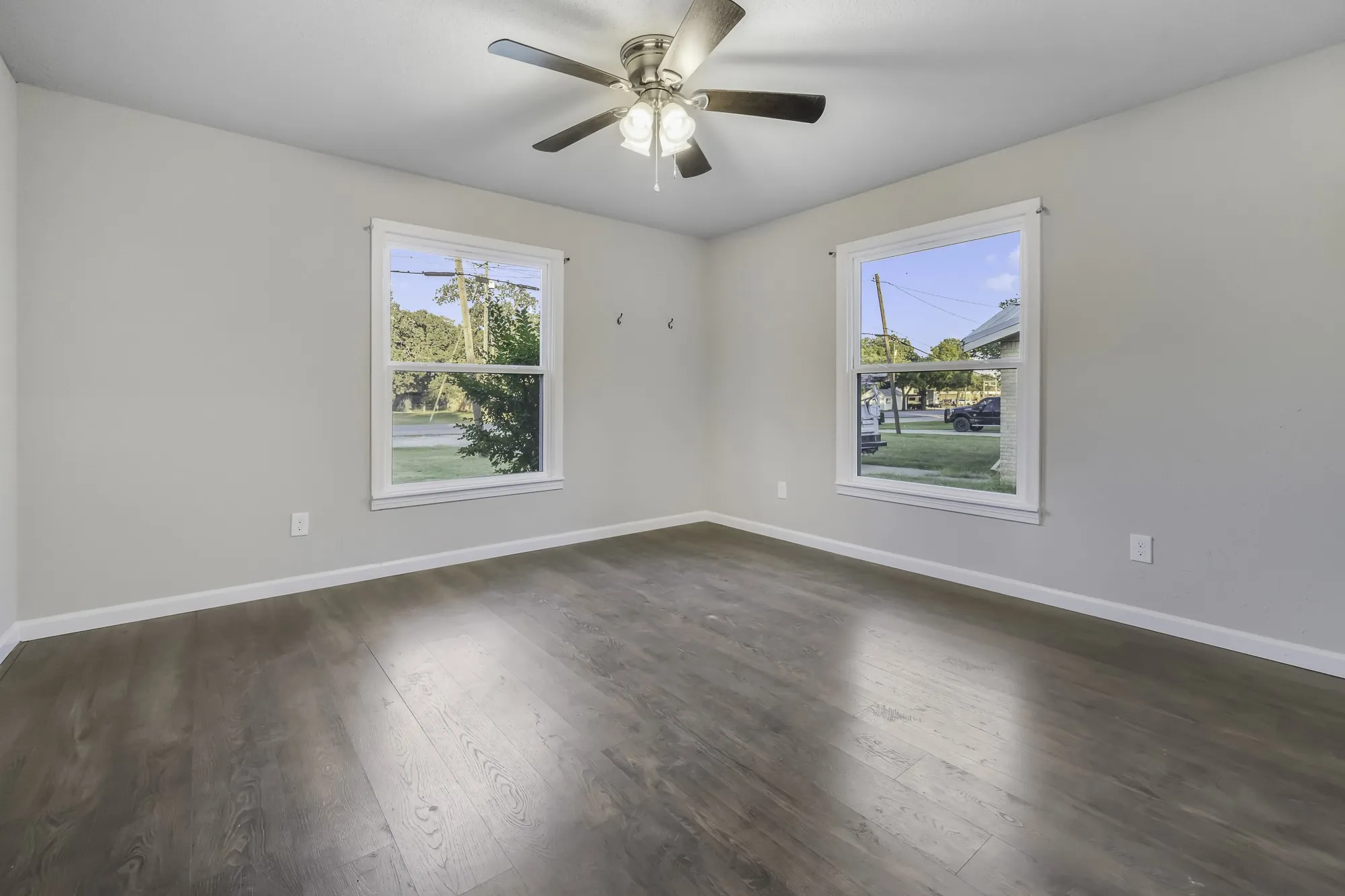 Spare room featuring dark wood finished floors and a ceiling fan