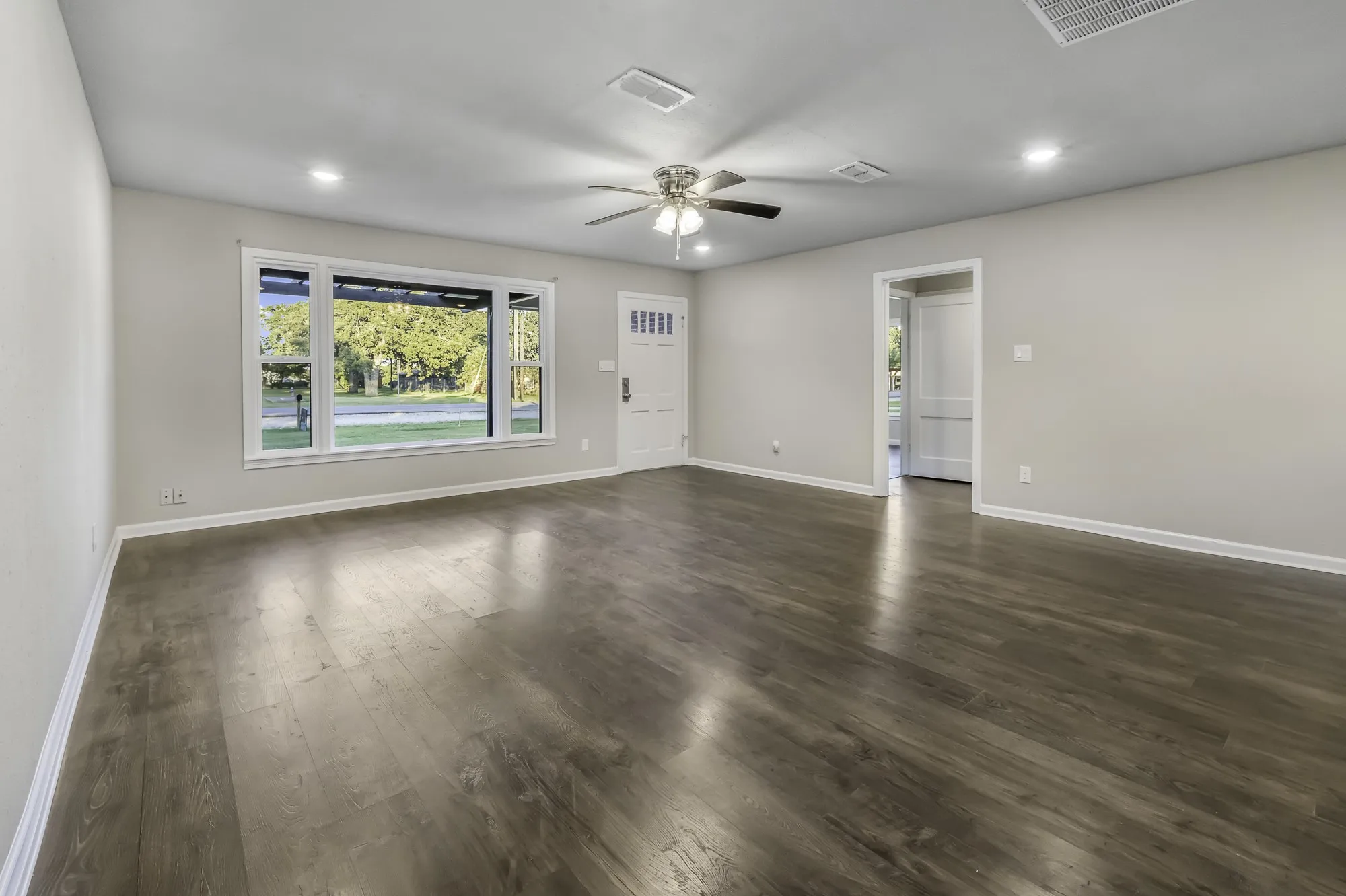 Empty room with dark wood-style flooring, recessed lighting, and a ceiling fan