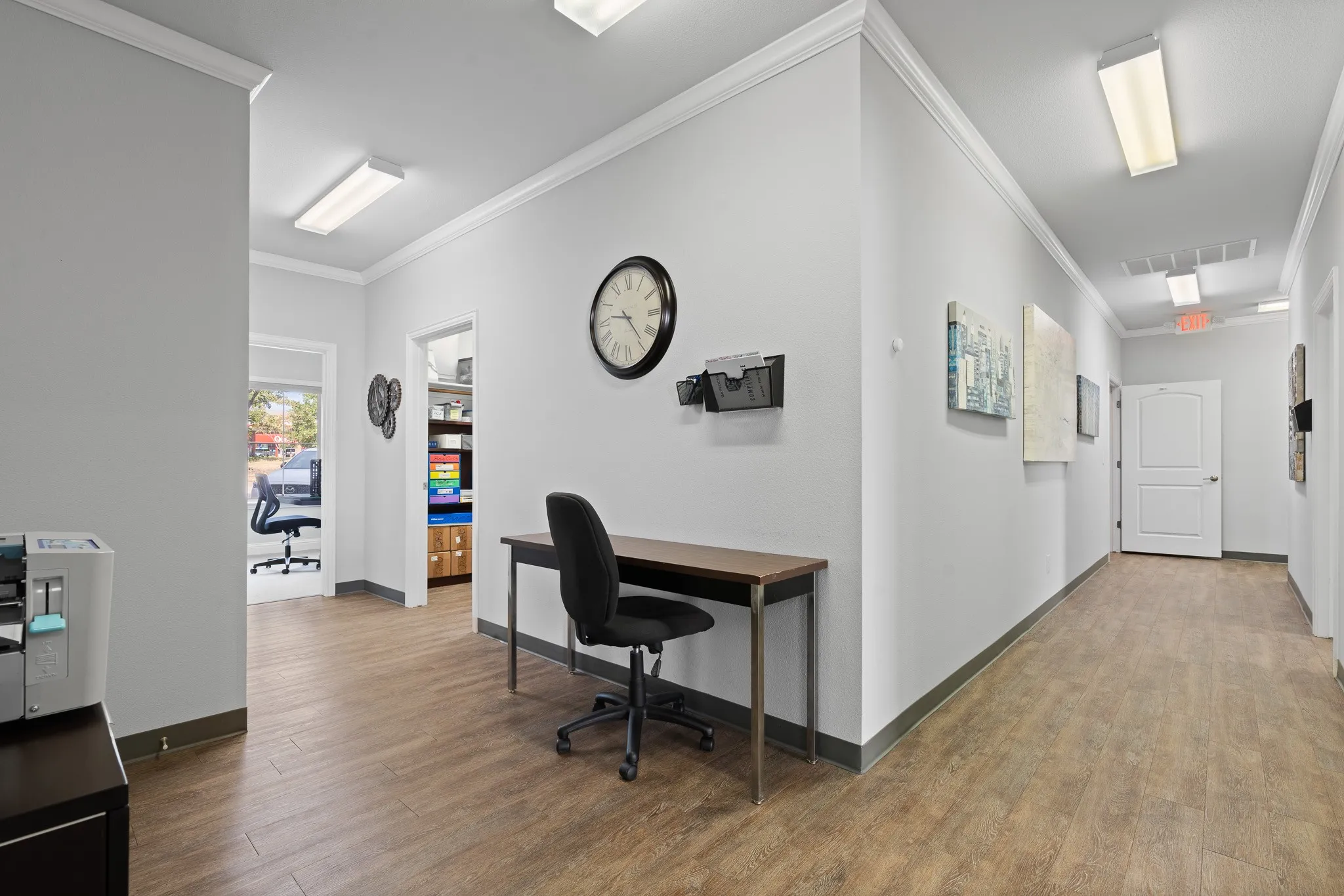 Hallway area leading to front conference room with wall of windows for natural lighting and storage room