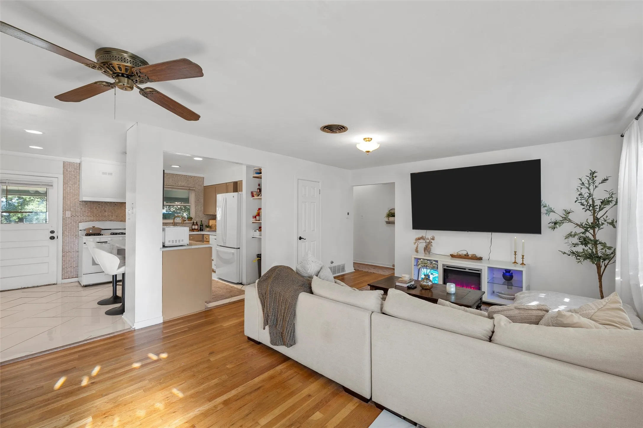Living area with light wood-style floors, recessed lighting, and ceiling fan