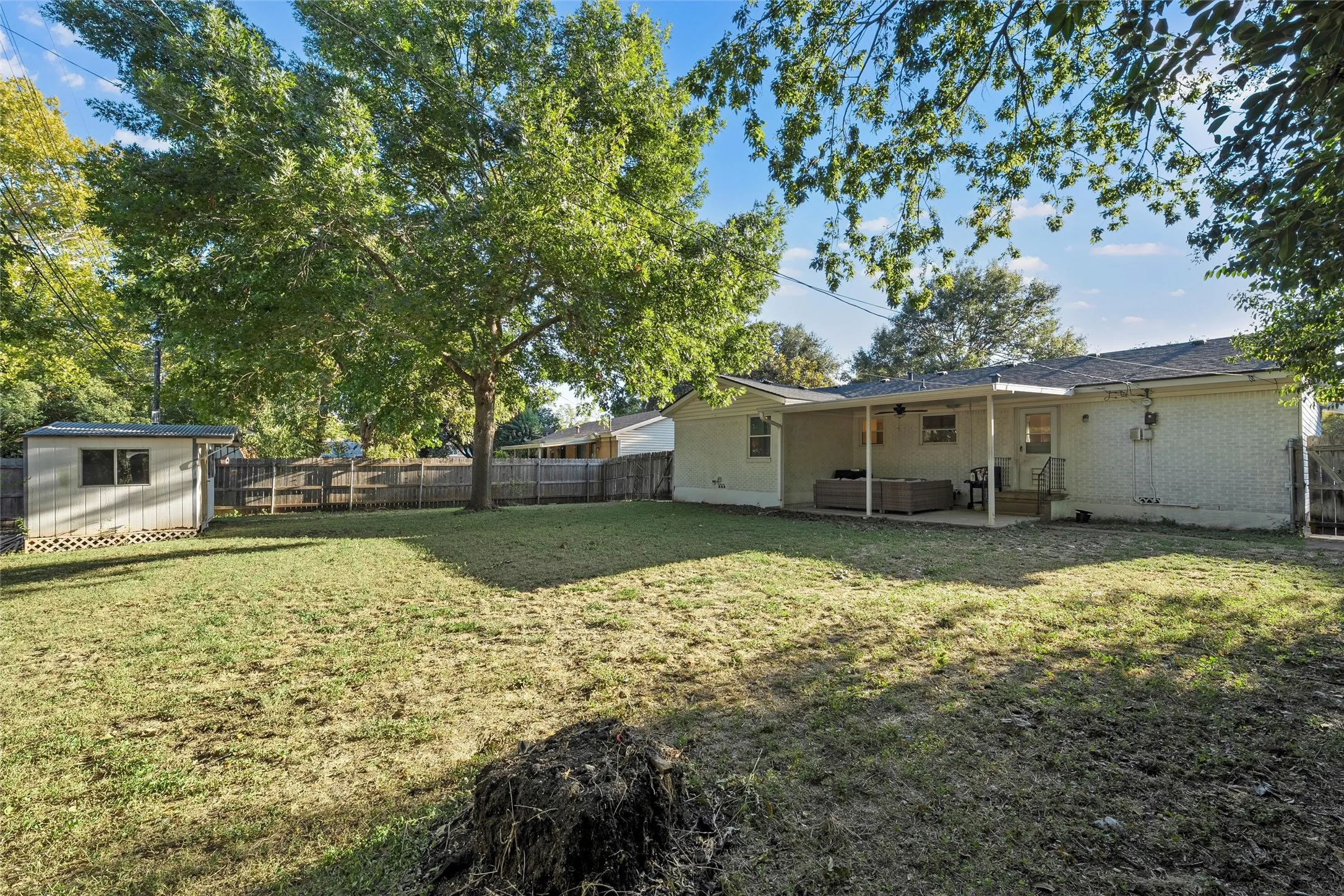 Fenced backyard with a patio area and a shed