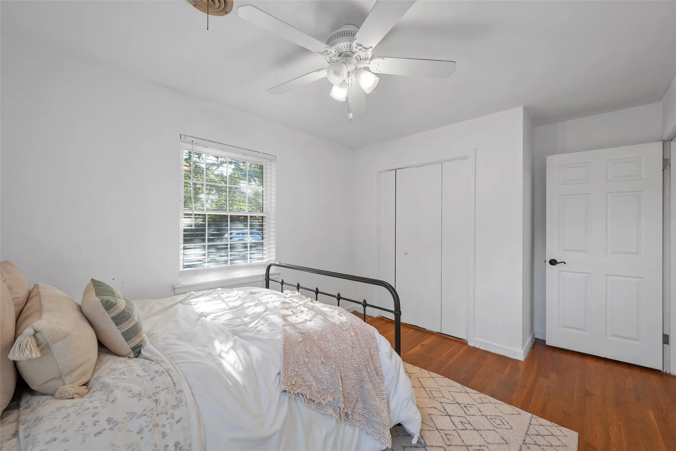 Bedroom featuring wood finished floors, a ceiling fan, and a closet