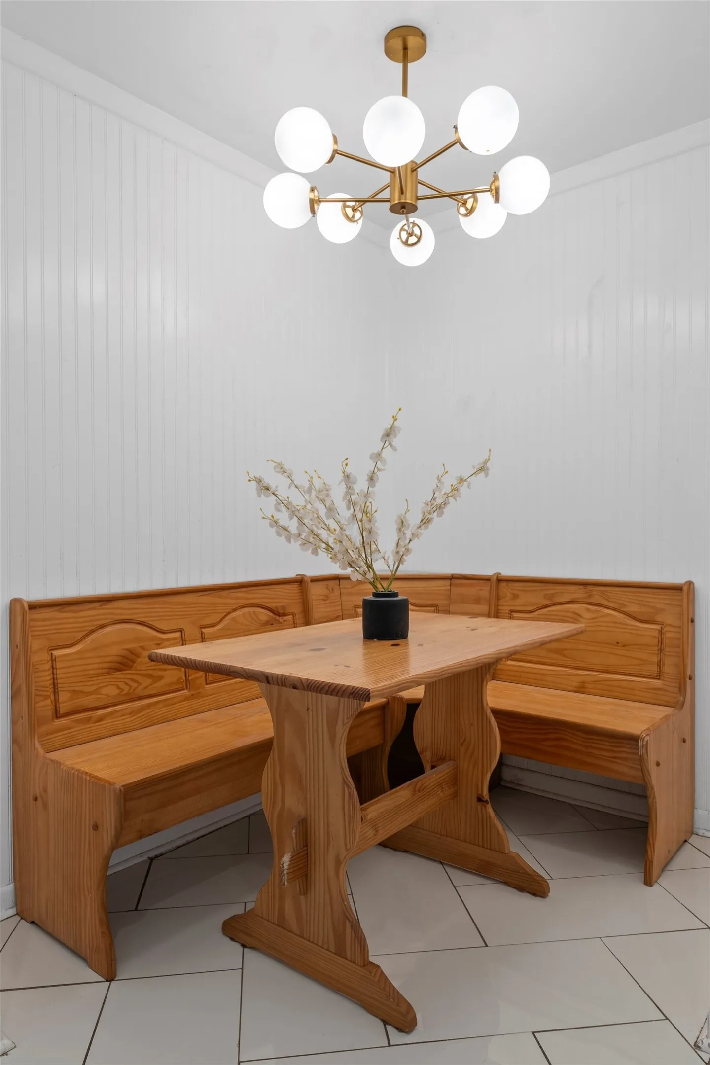 Tiled dining room with a chandelier and wood walls