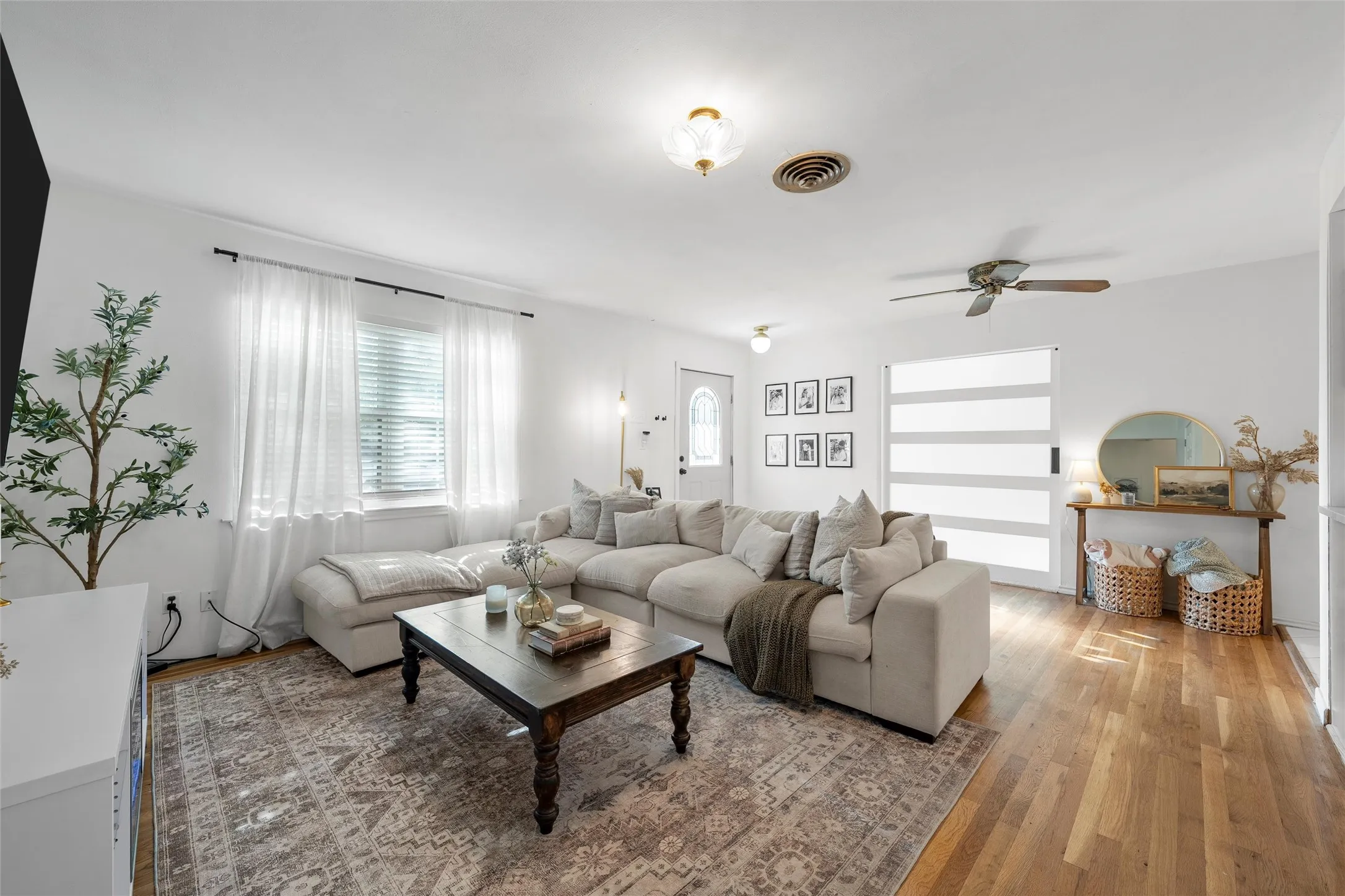 Living room with wood-type flooring and ceiling fan