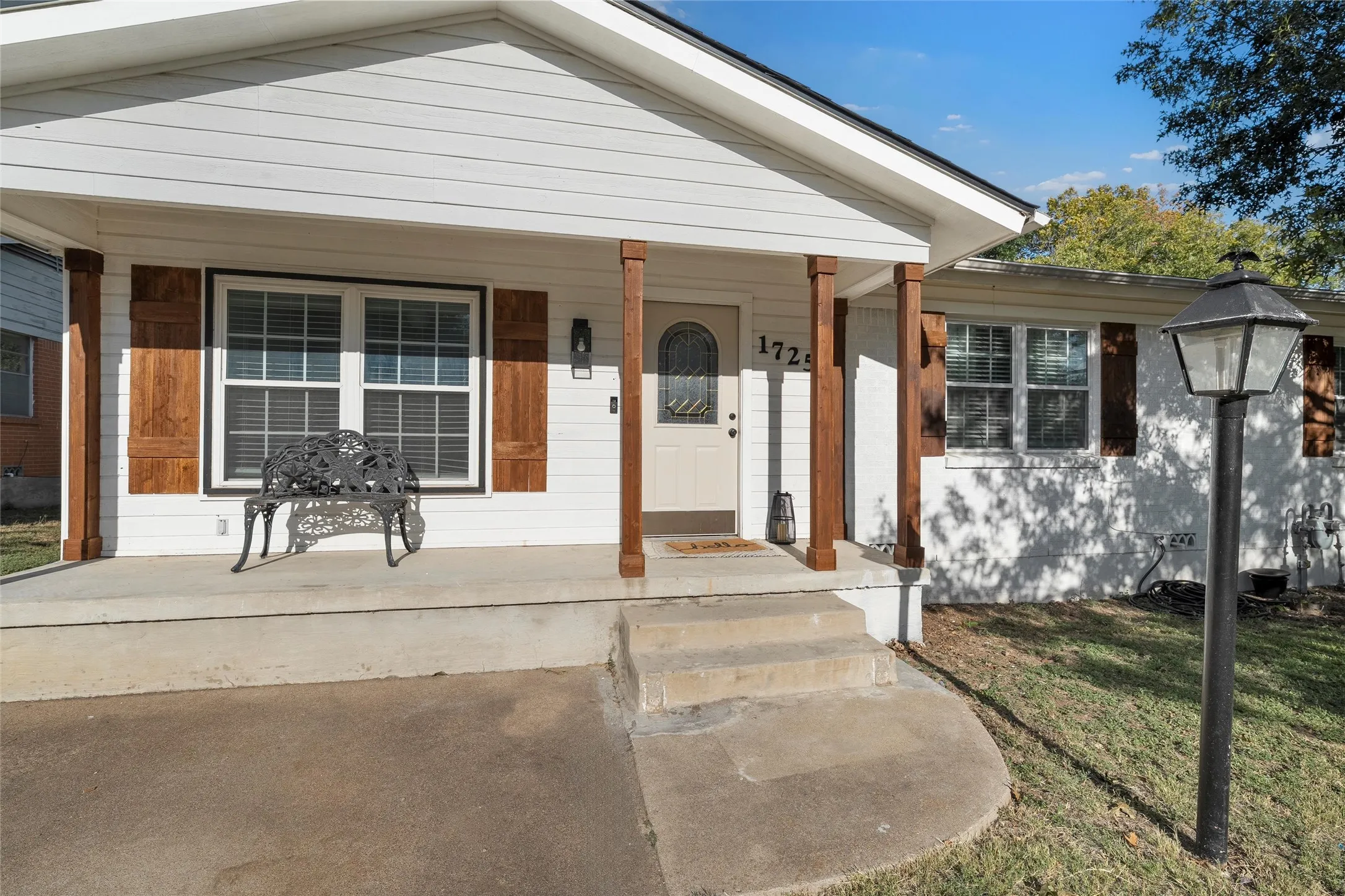 Doorway to property with a porch and a yard
