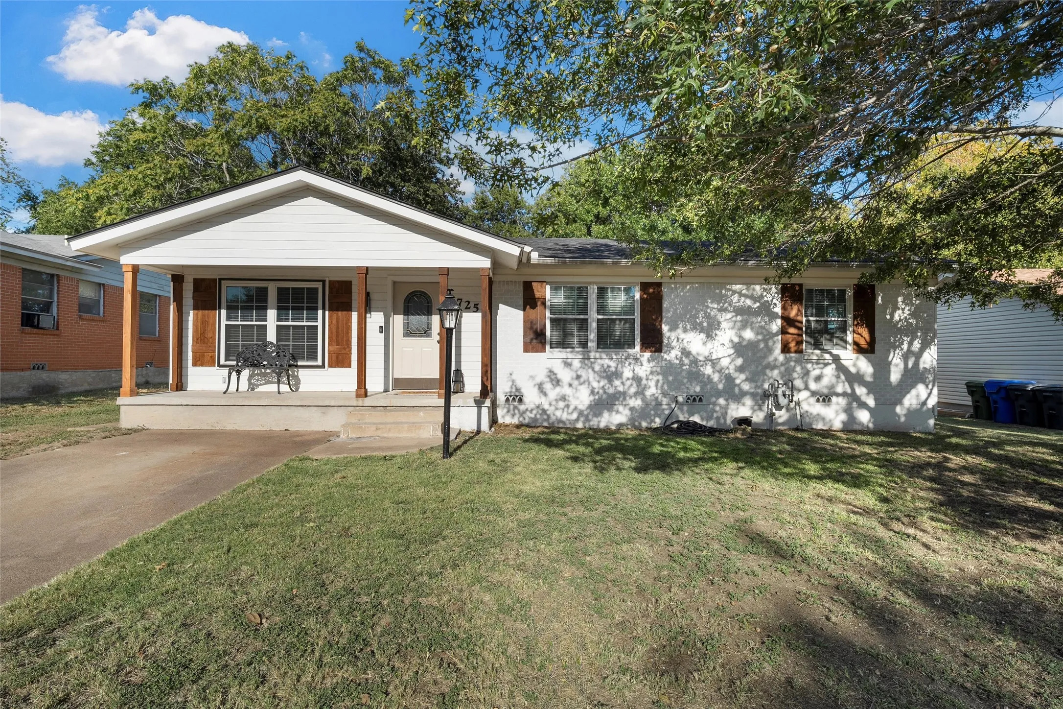 Ranch-style home with covered porch and a front yard