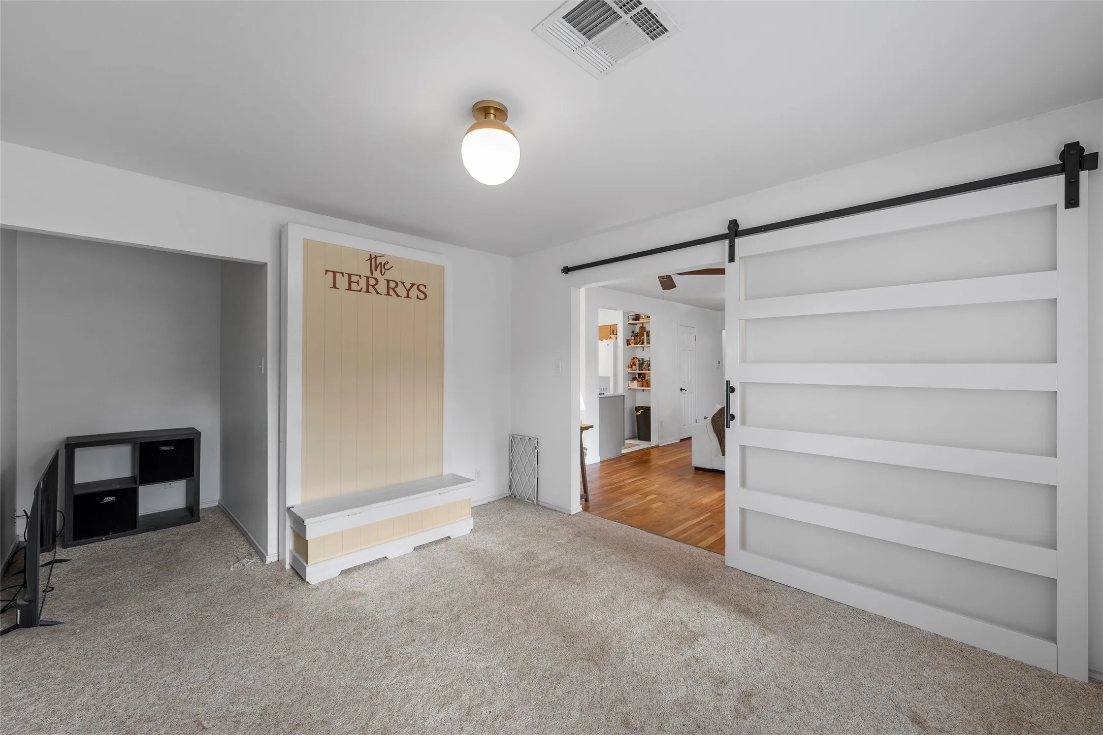 Carpeted spare room featuring a barn door