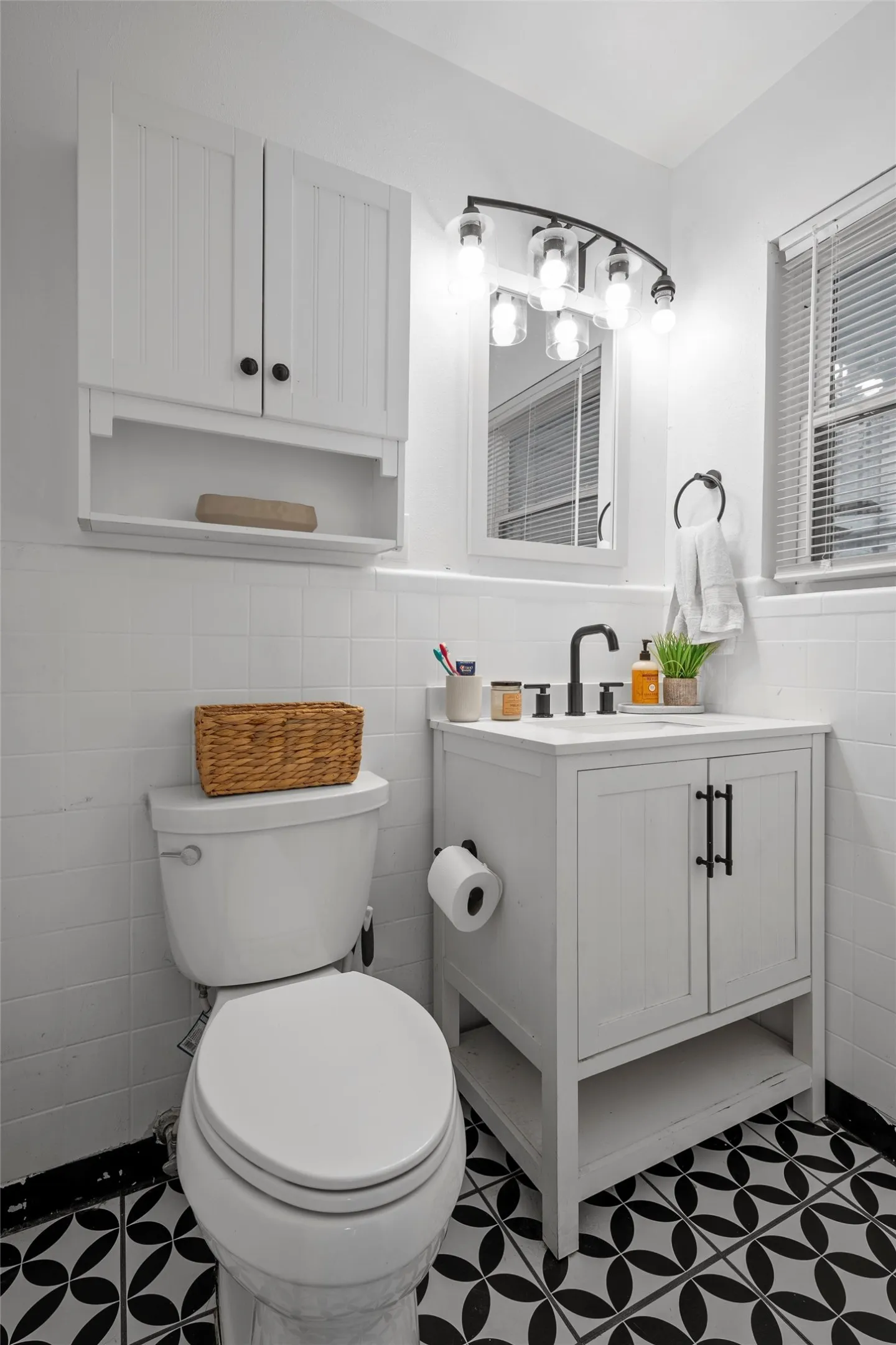 Half bath with tile walls, wainscoting, dark flooring, and vanity
