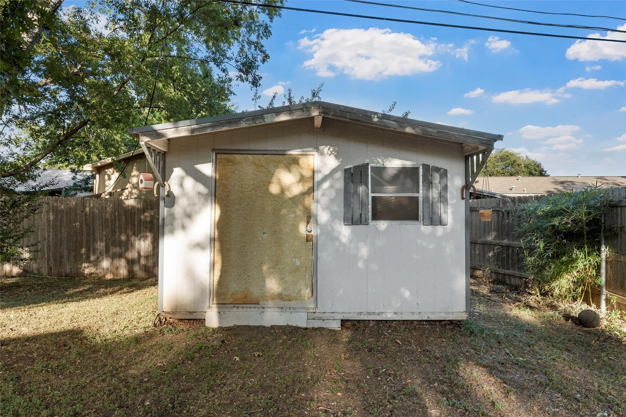 View of property exterior featuring a fenced backyard and a storage unit