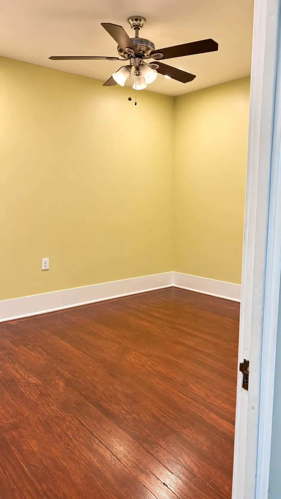 Bedroom 1 with wood finished floors and a ceiling fan