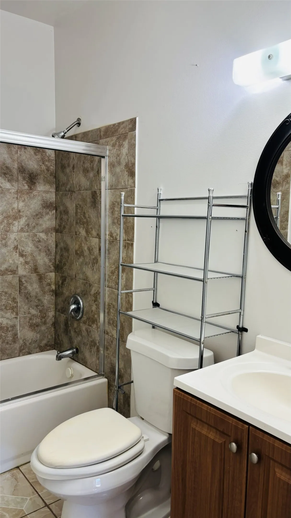 Bathroom featuring bathing tub / shower combination, vanity, and tile patterned flooring