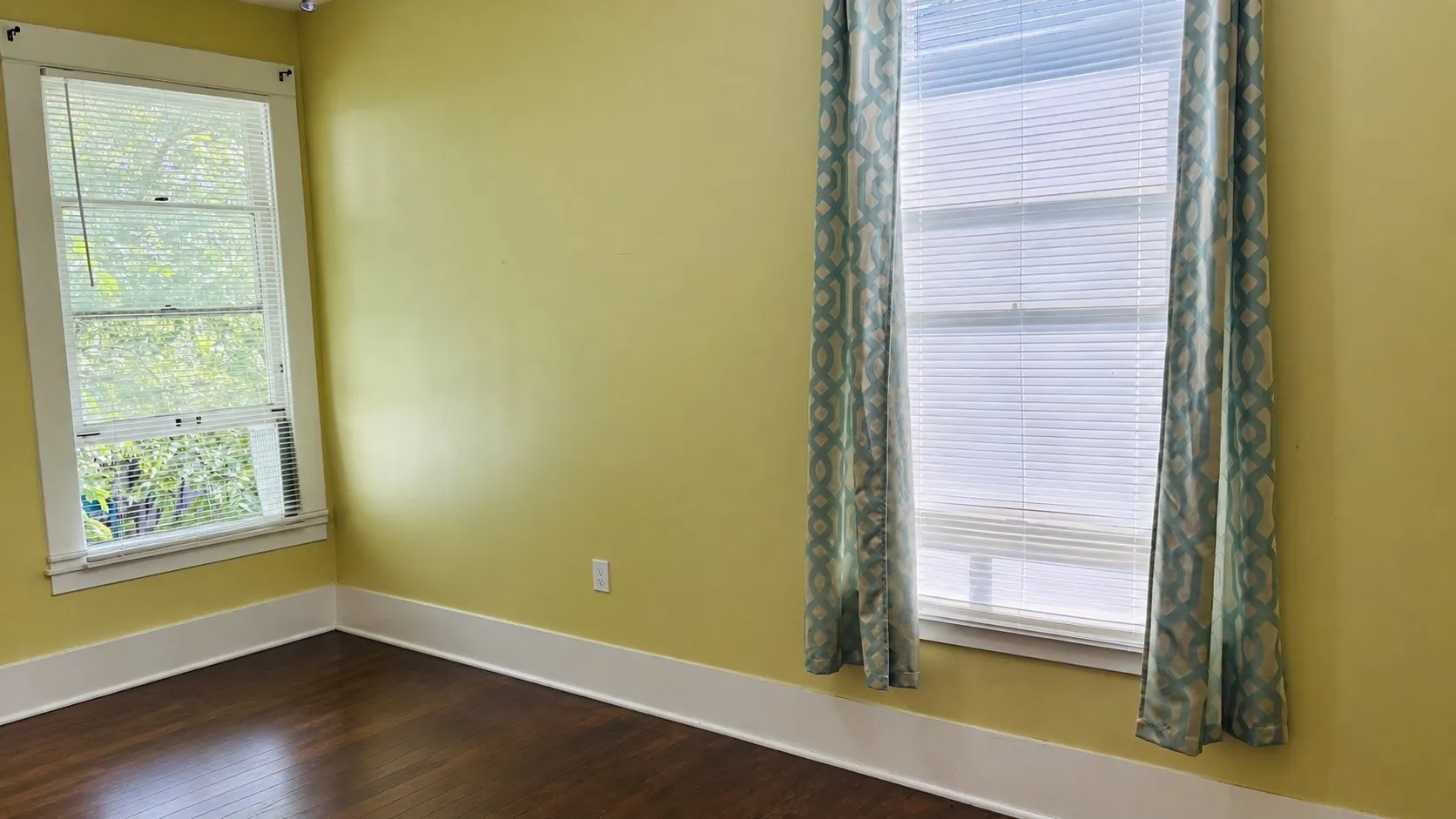 Bedroom 2 with dark wood finished floors and baseboards