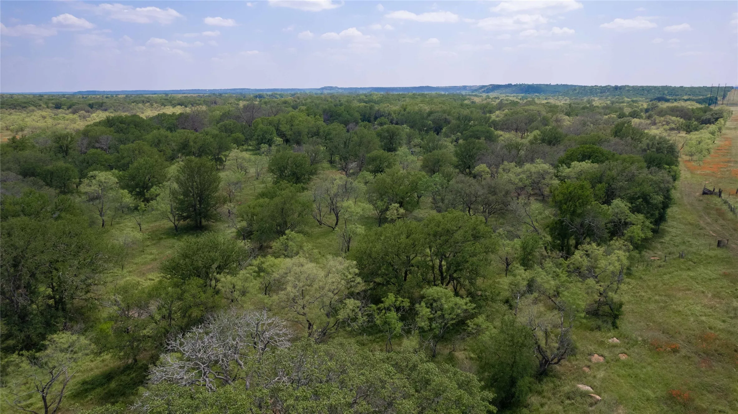 Aerial view of property and surrounding area featuring a heavily wooded area