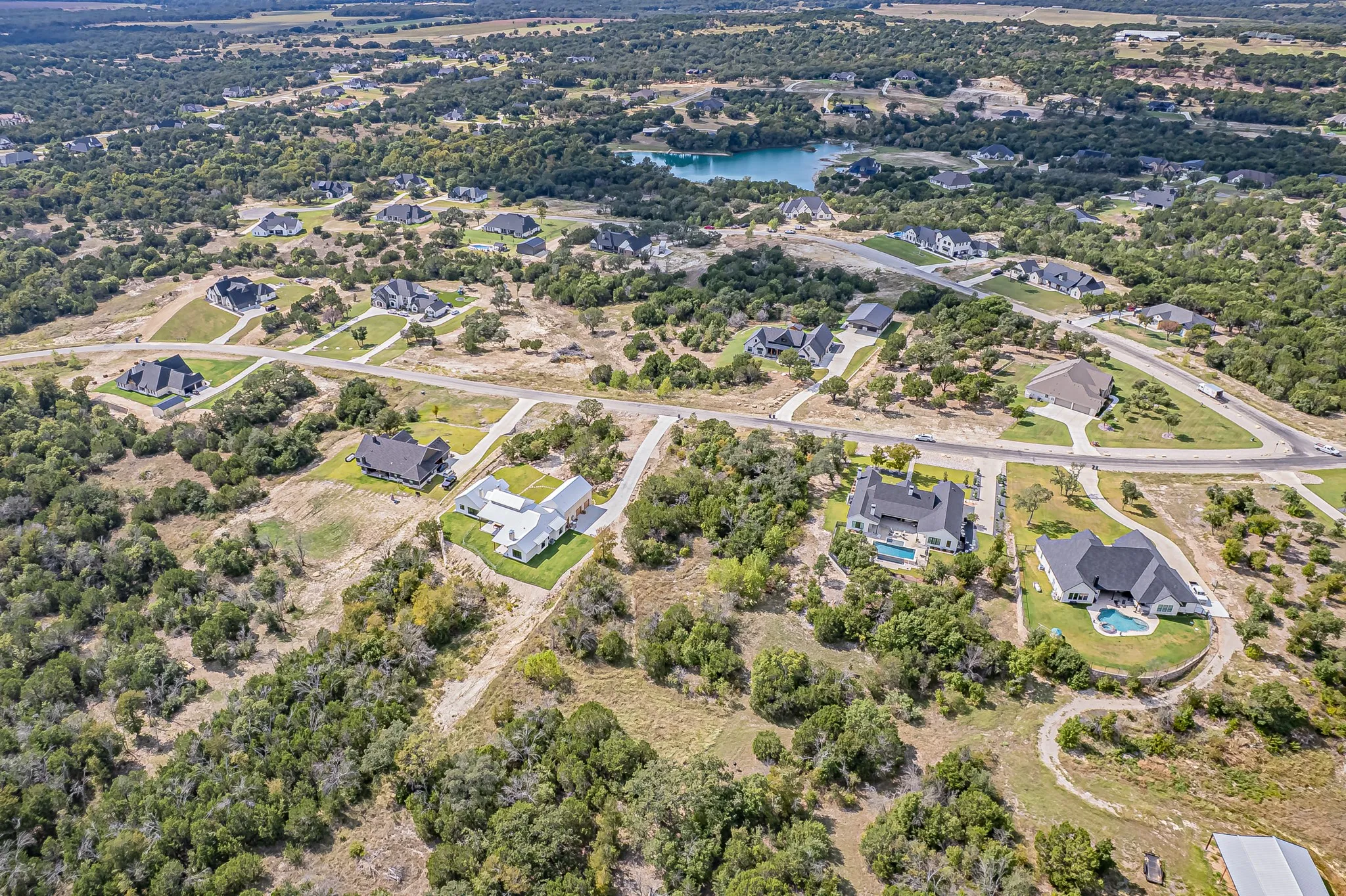 Aerial view of property and surrounding area featuring nearby suburban area and a nearby body of water