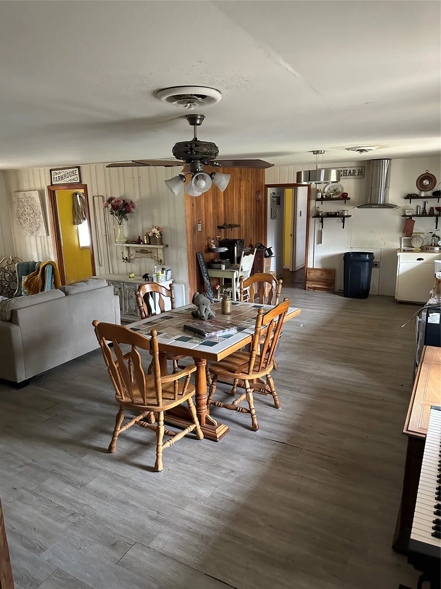Dining area featuring wood finished floors, ceiling fan, and wood walls