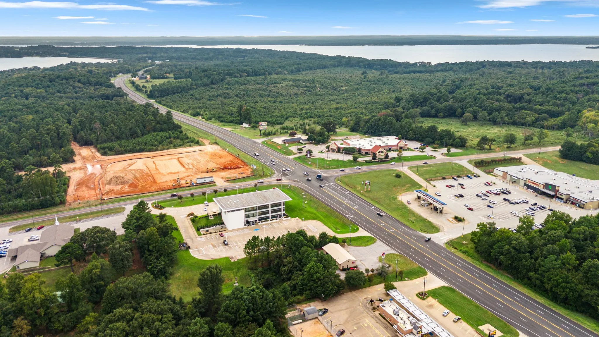 Aerial view of property and surrounding area with a forest and a large body of water