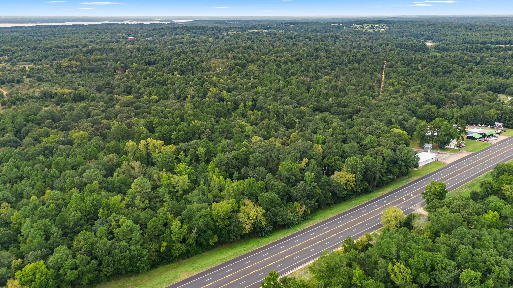 Drone / aerial view of a major roadway and a heavily wooded area