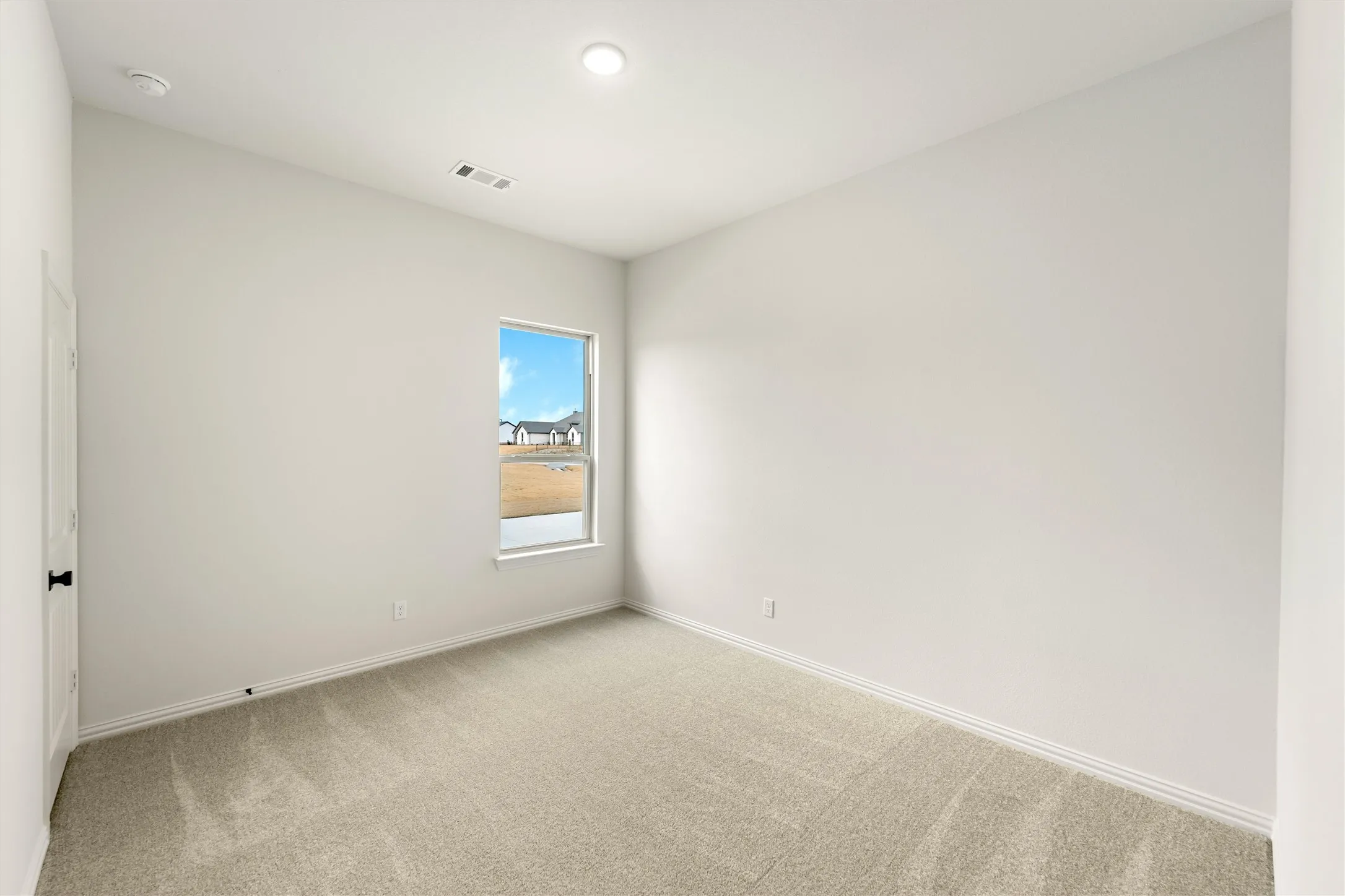 Unfurnished room with light colored carpet and baseboards