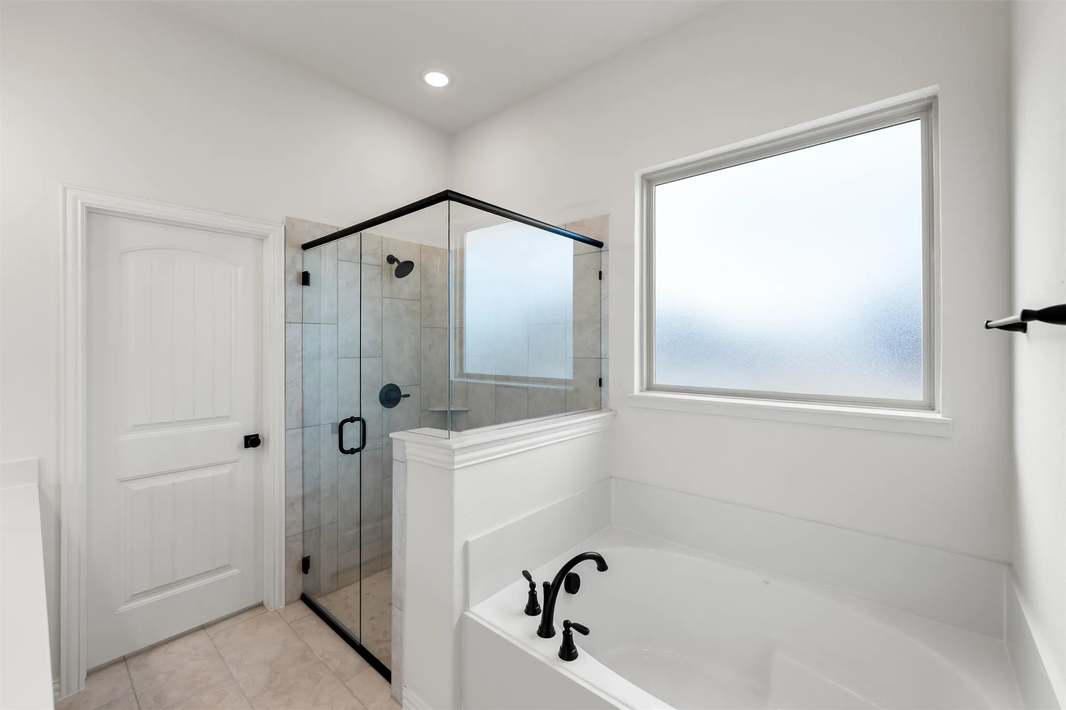 Bathroom with a shower stall and a bath