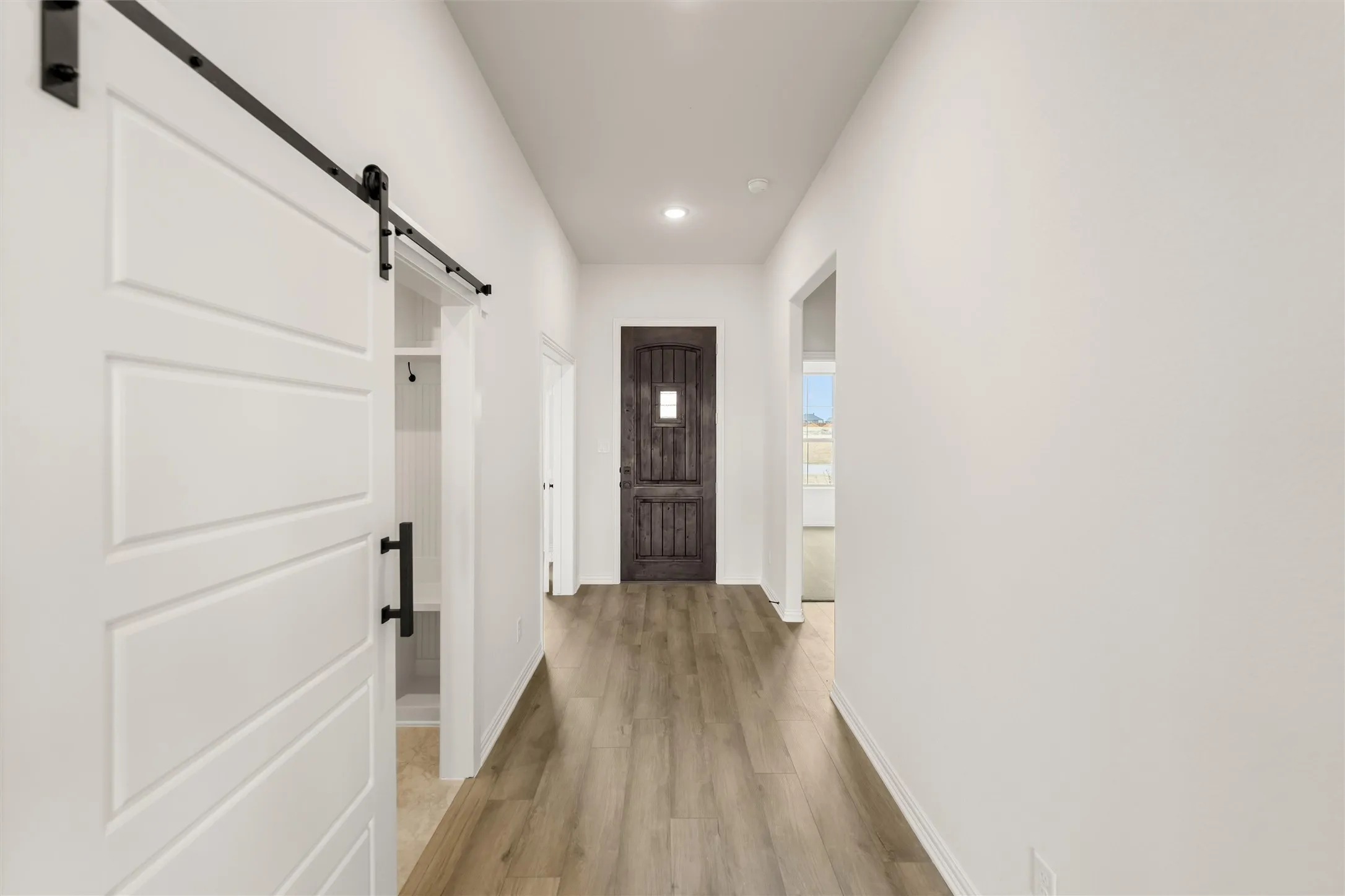 Entryway featuring a barn door, wood finished floors, and recessed lighting