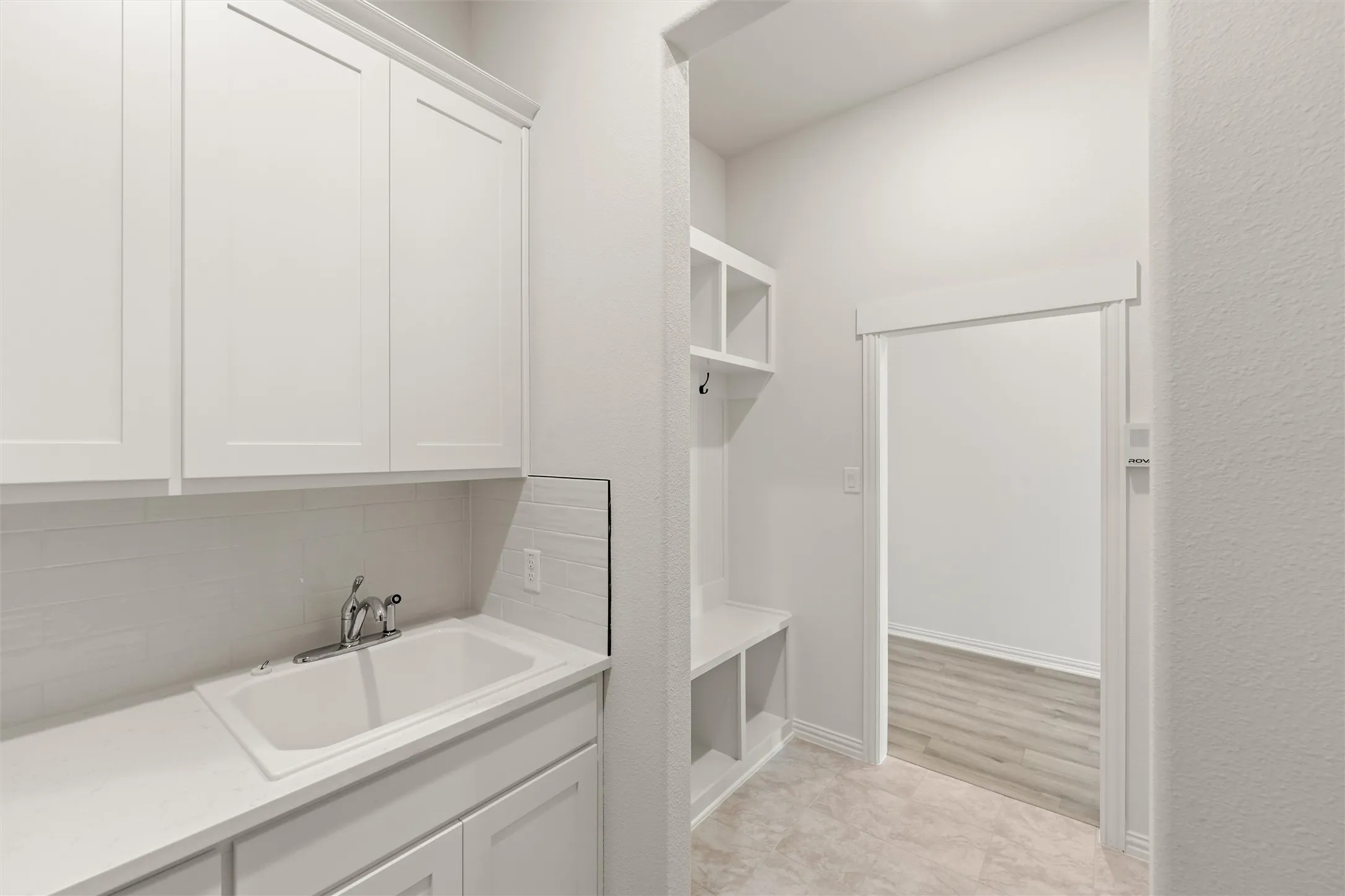 Mudroom with a sink and baseboards