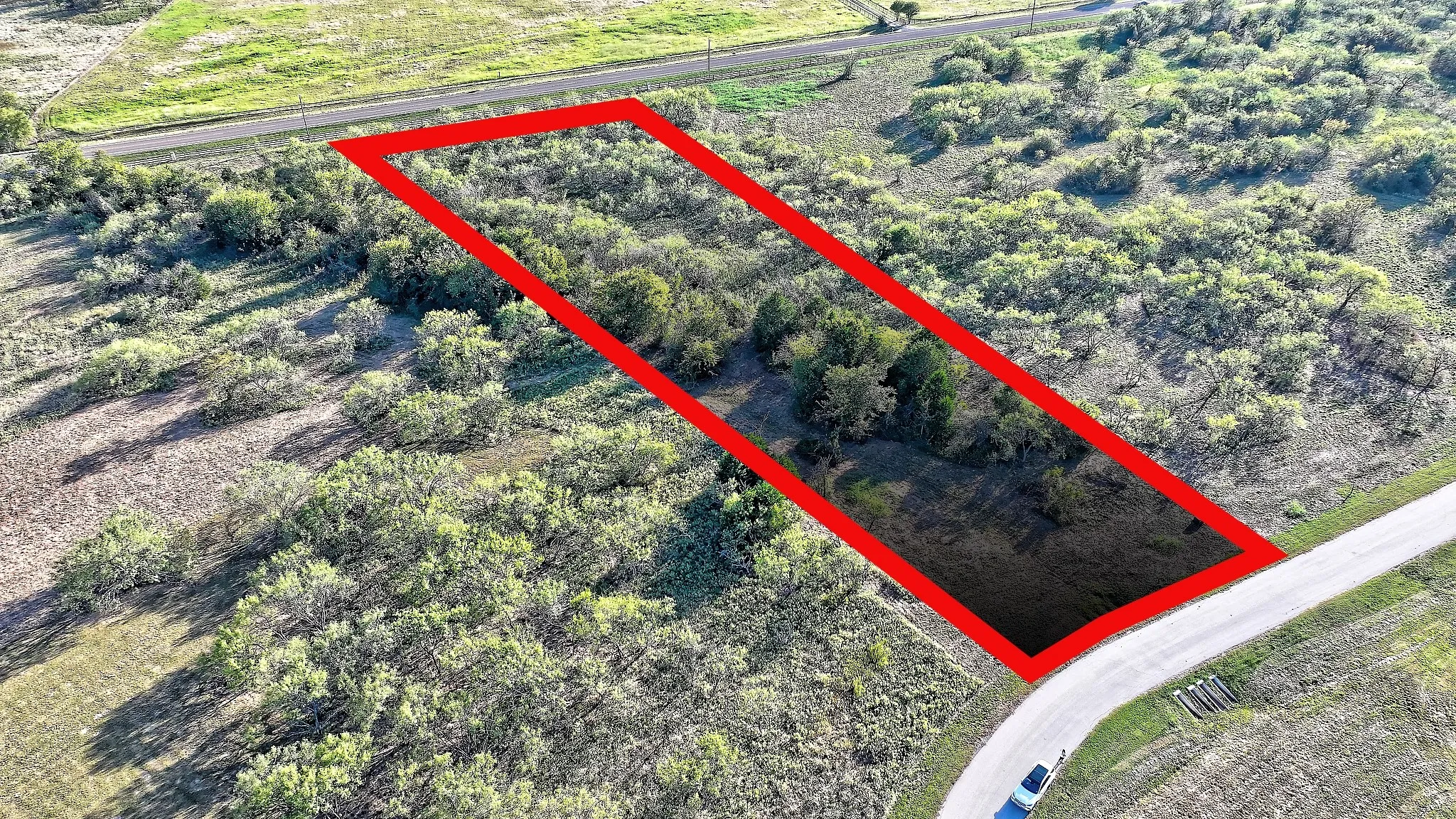 Aerial view of property and surrounding area with property parcel outlined