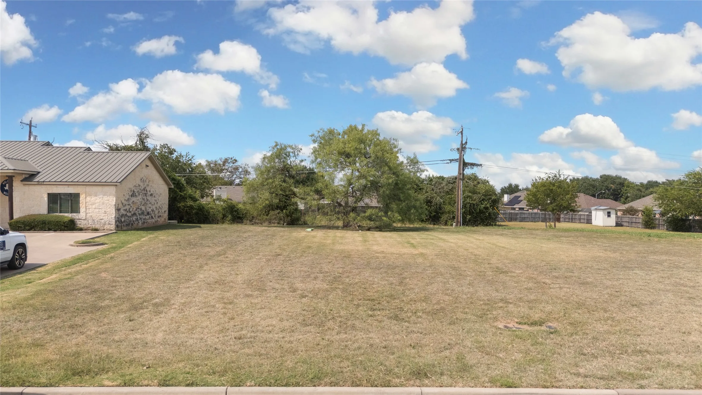 View of grassy yard featuring a storage shed