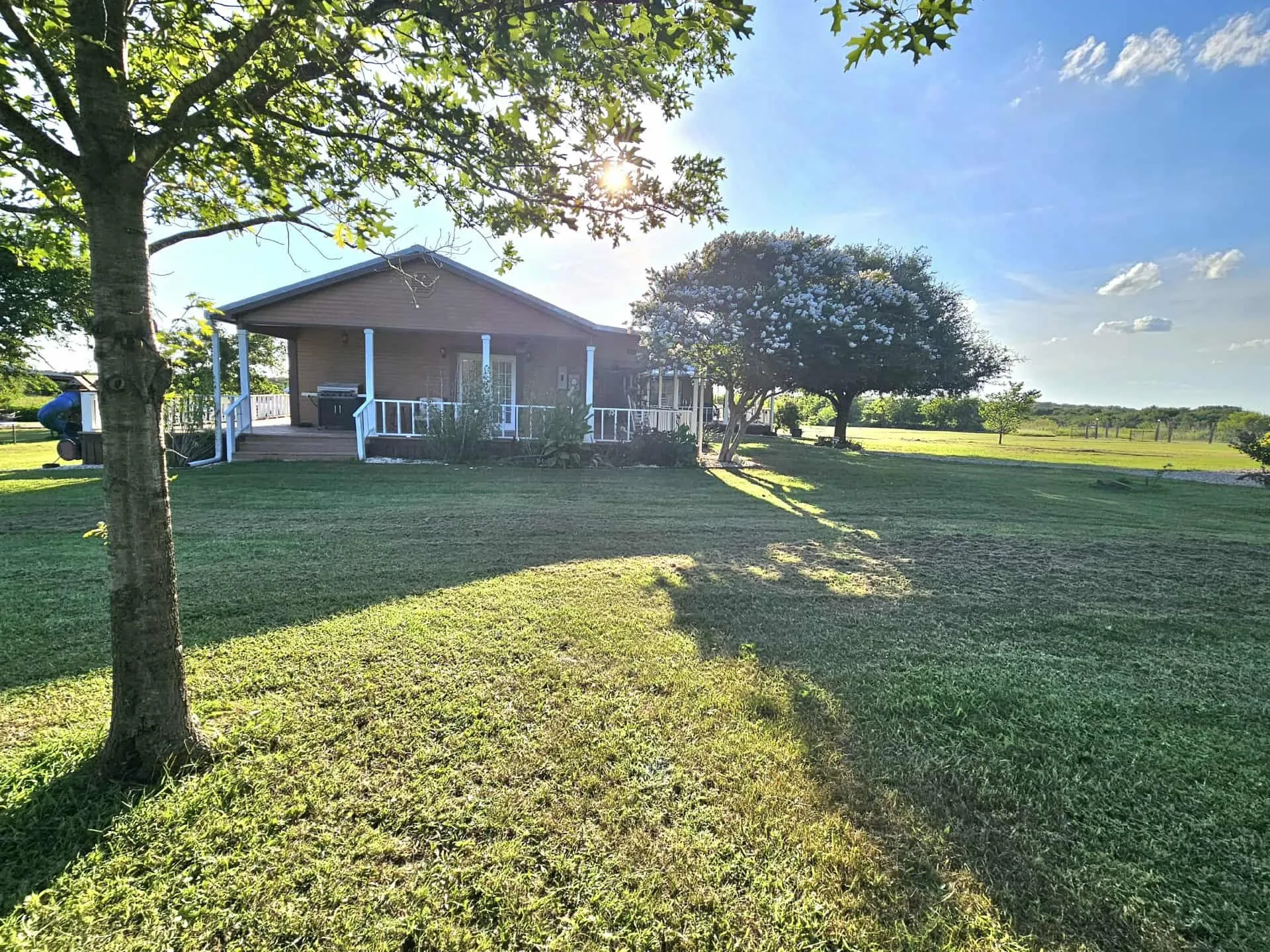 View of grassy yard featuring covered porch