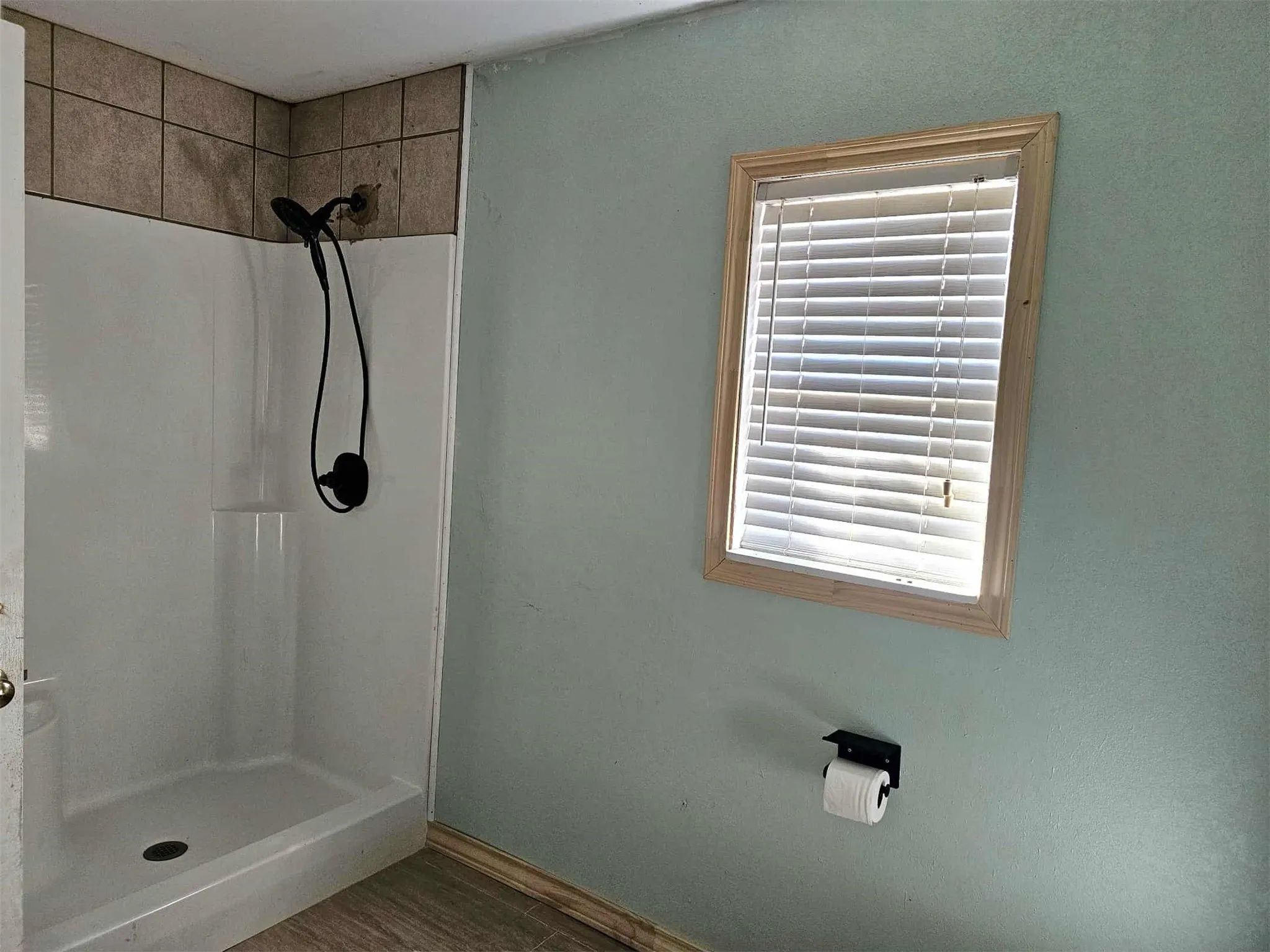 Full bath featuring a stall shower and dark wood-type flooring