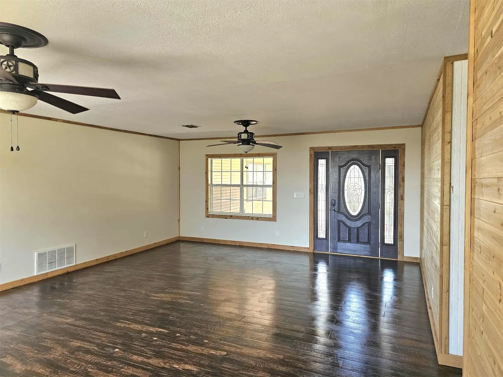 Foyer entrance featuring ornamental molding, dark wood-type flooring, and a textured ceiling