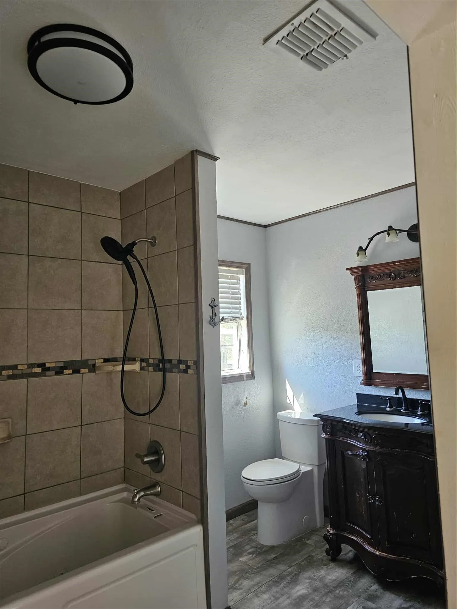 Bathroom featuring washtub / shower combination and vanity