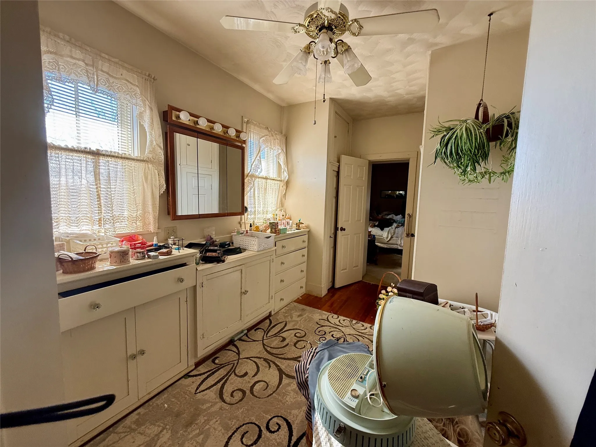 Ensuite bathroom with vanity, a ceiling fan, and wood finished floors