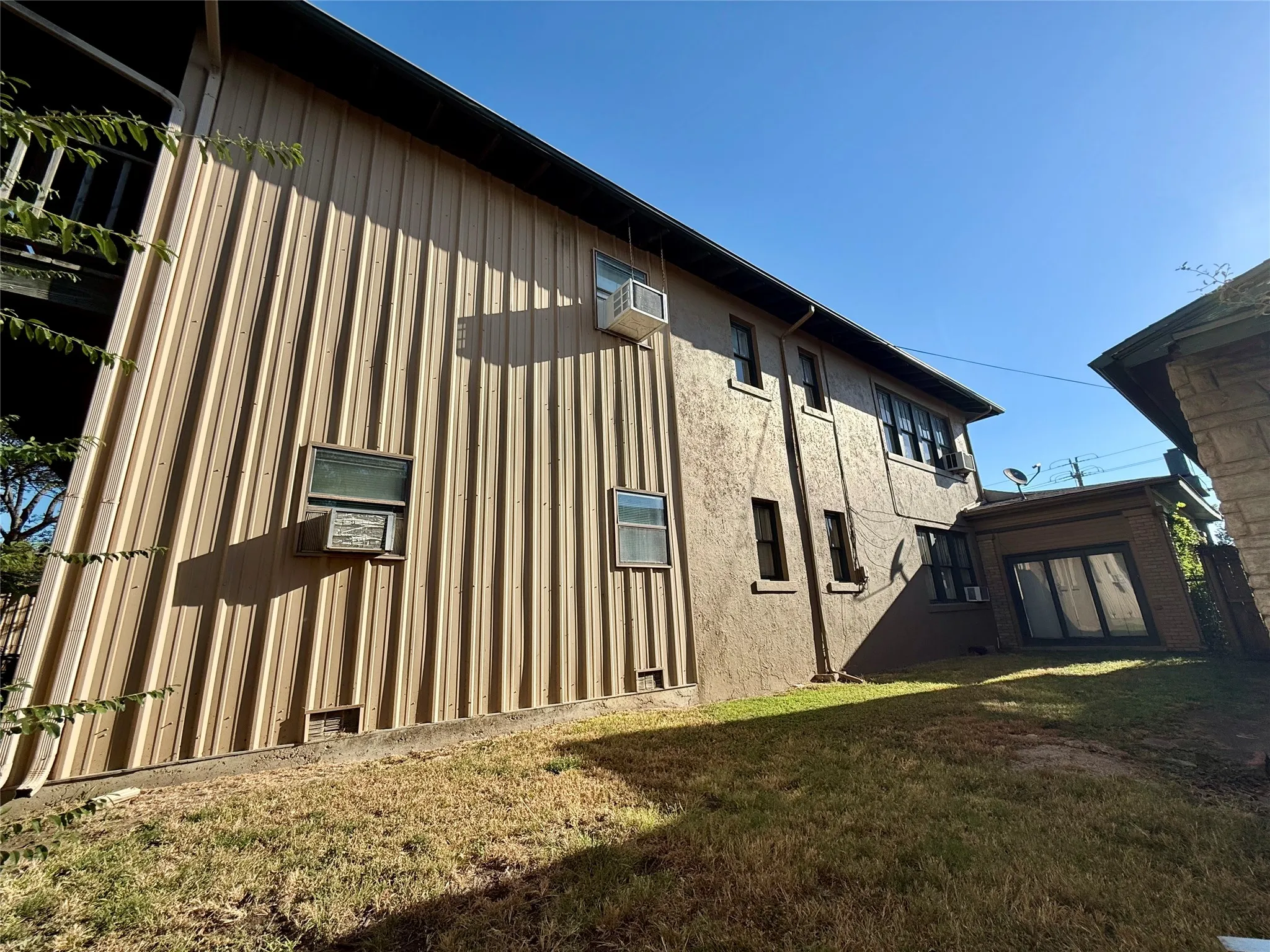 View of property exterior with a lawn and board and batten siding