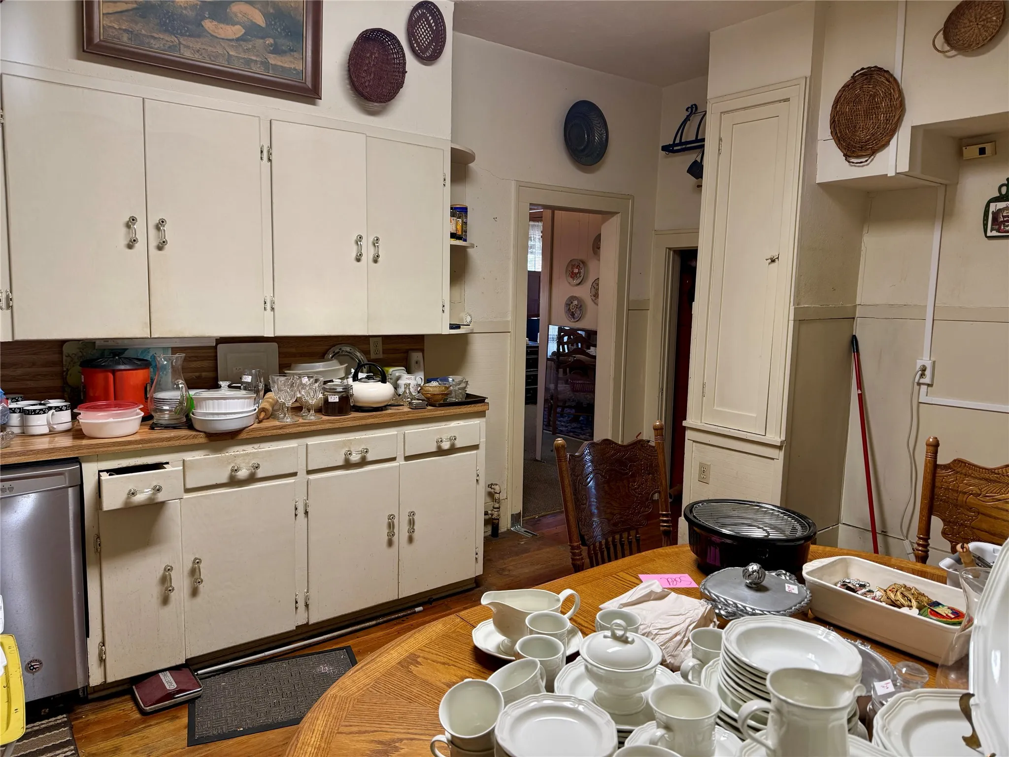 Kitchen with stainless steel dishwasher, white cabinetry, light wood finished floors, and open shelves
