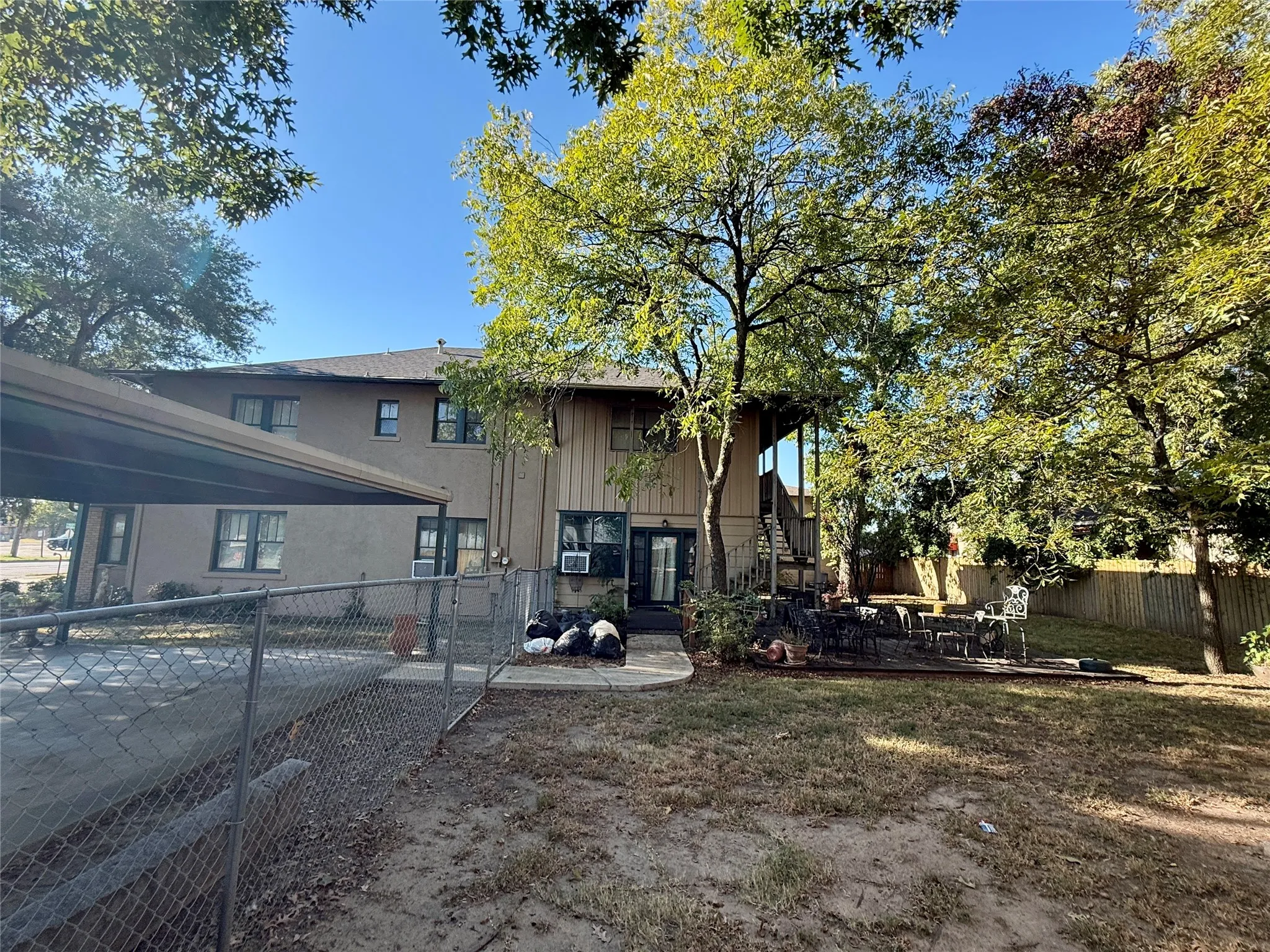 Rear view of property featuring a patio area, stairs, a gate, and cooling unit