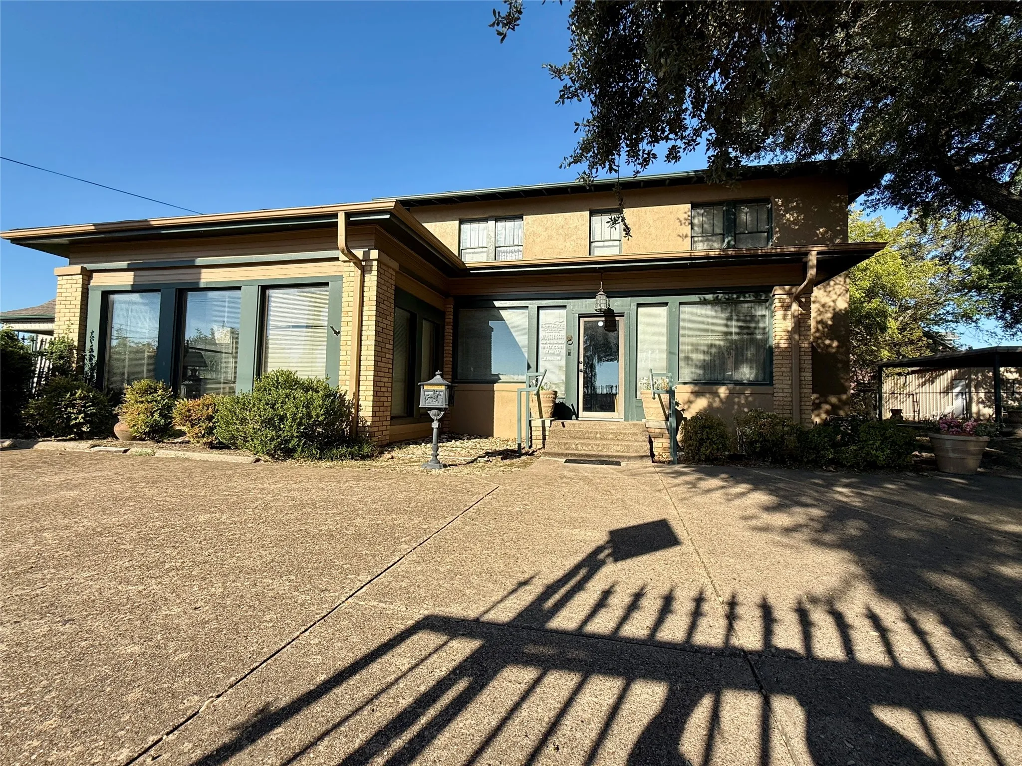Back of property with brick siding and a patio